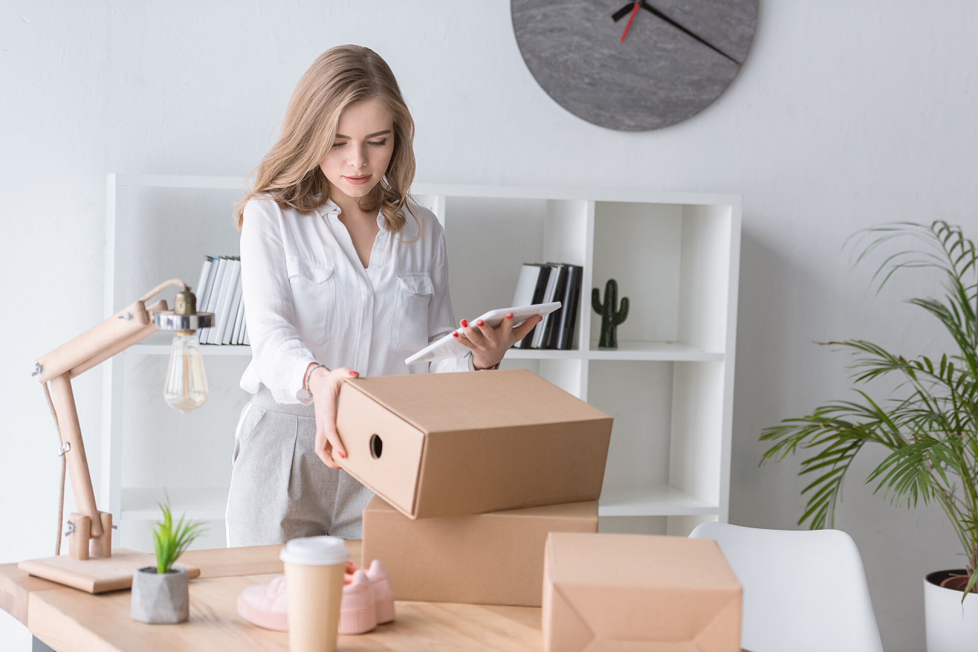 年轻女实业家包装纸板盒年轻女实业家的画像与纸板盒和片剂在手