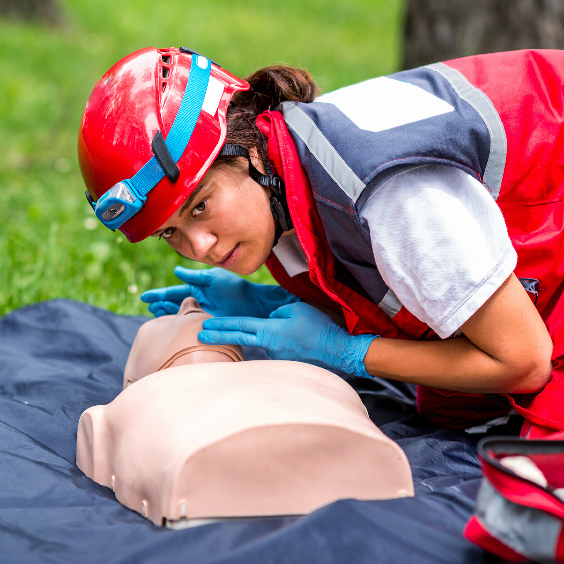 户外女救生员用人体模型进行急救训练女性 cpr 在户外的 cpr 训练