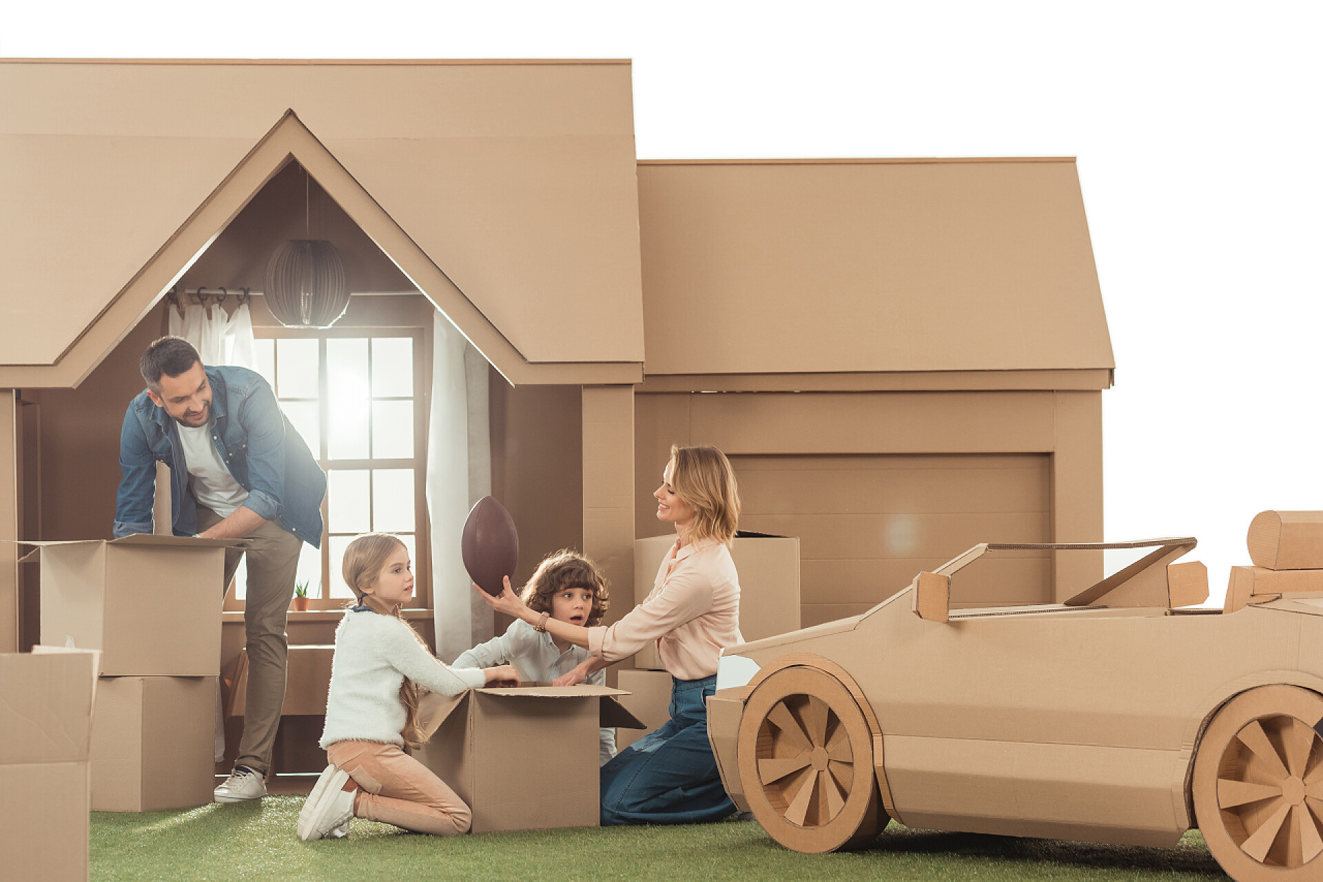 纸箱房子前整理东西的一家人搬迁