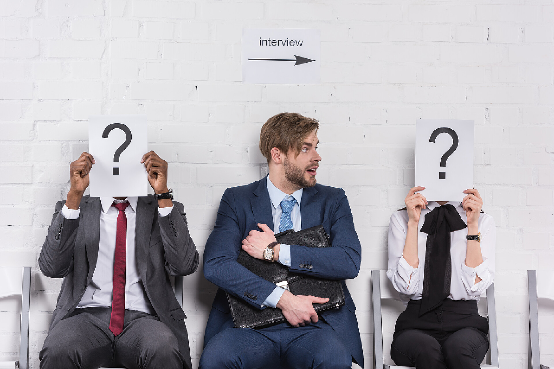 求职面试者手拿问号白纸白种商人和多民族商业人士在等待求职面试时拿着问号的名片