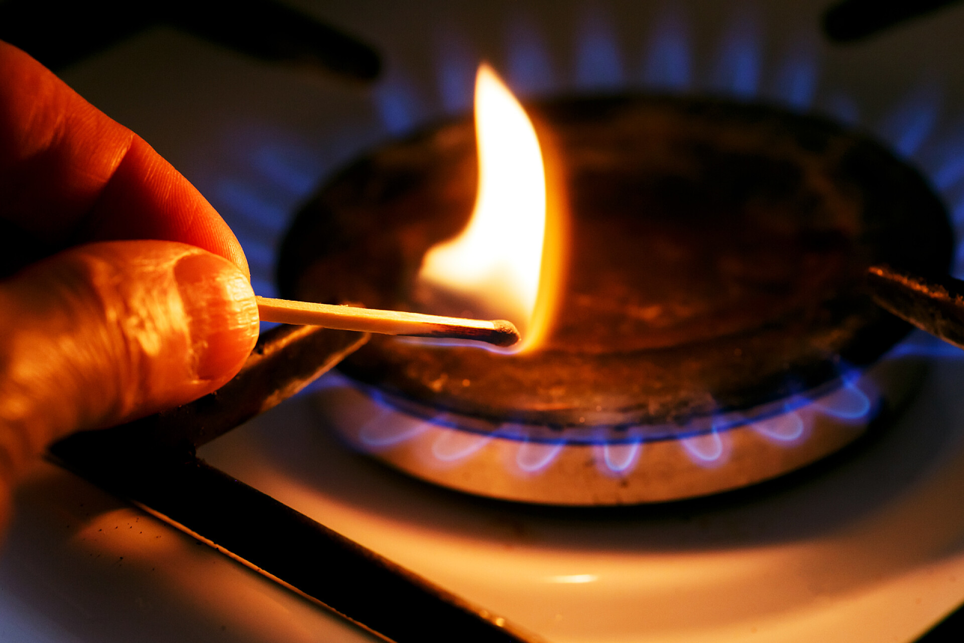 用火柴棍给煤气炉点火的特写镜头煤气炉。公用事业条例草案概念