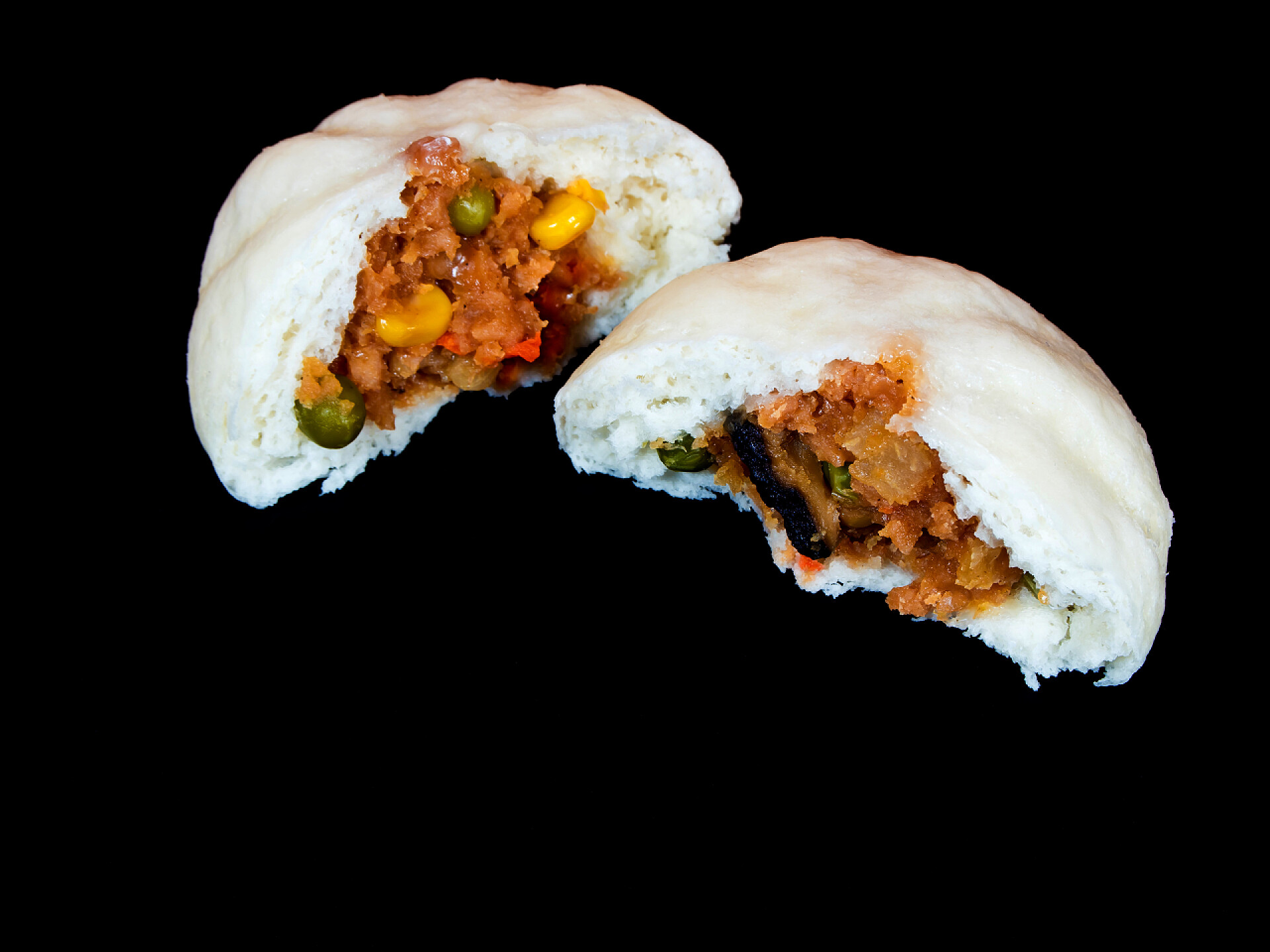 黑色背景上的肉包素菜蒸饺子内的蔬菜