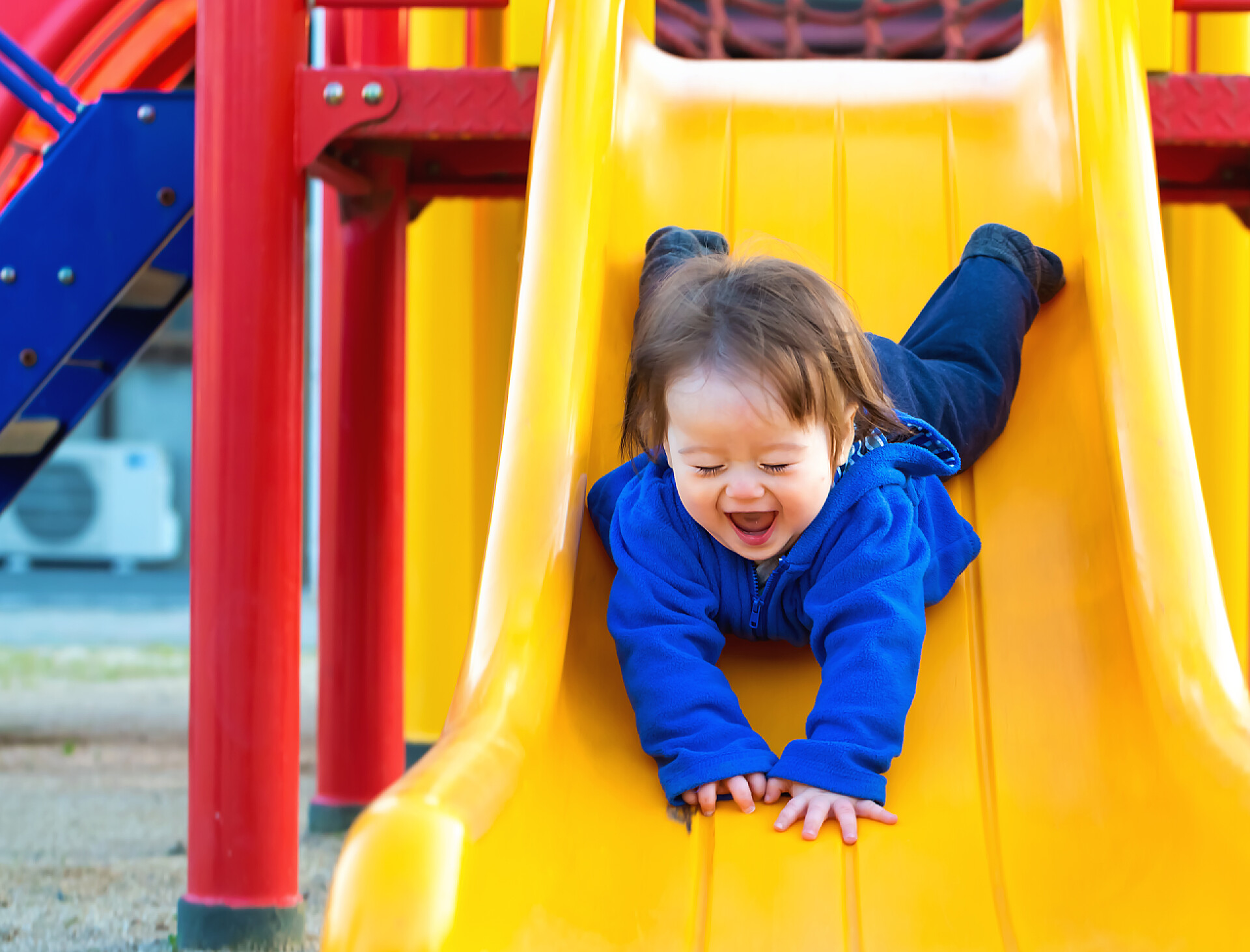 蹒跚学步的儿童在玩滑梯孩子在操场上玩耍