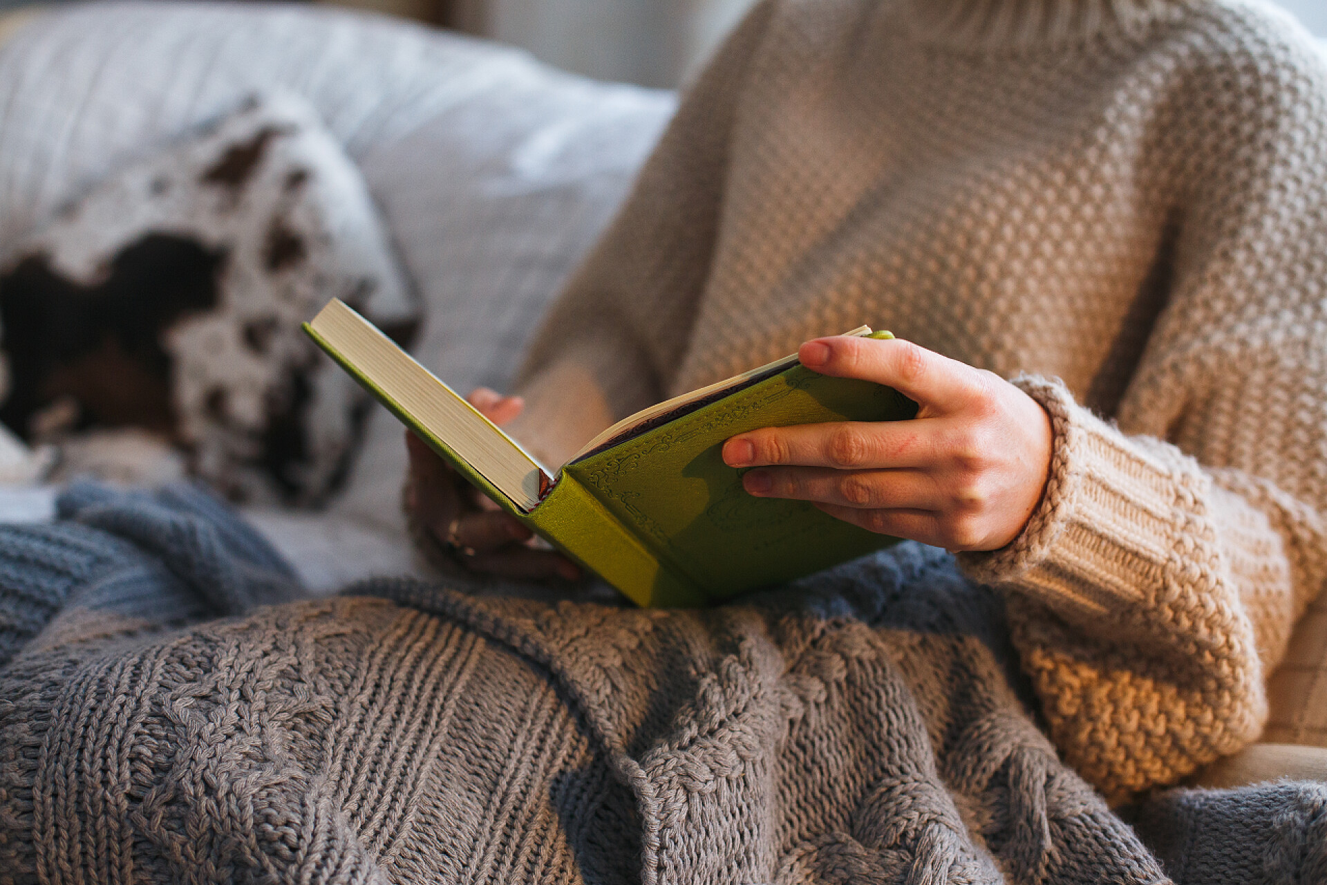 女人坐在舒适的椅子与披着针织格子在壁炉前面,冬天舒适的感觉