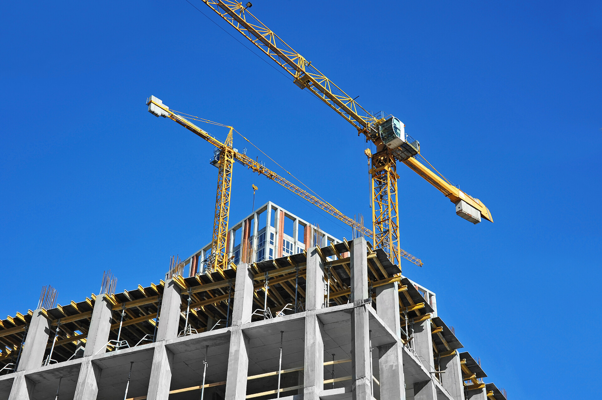 在蓝天下施工的起重机和建筑物起重机和高层建筑施工现场