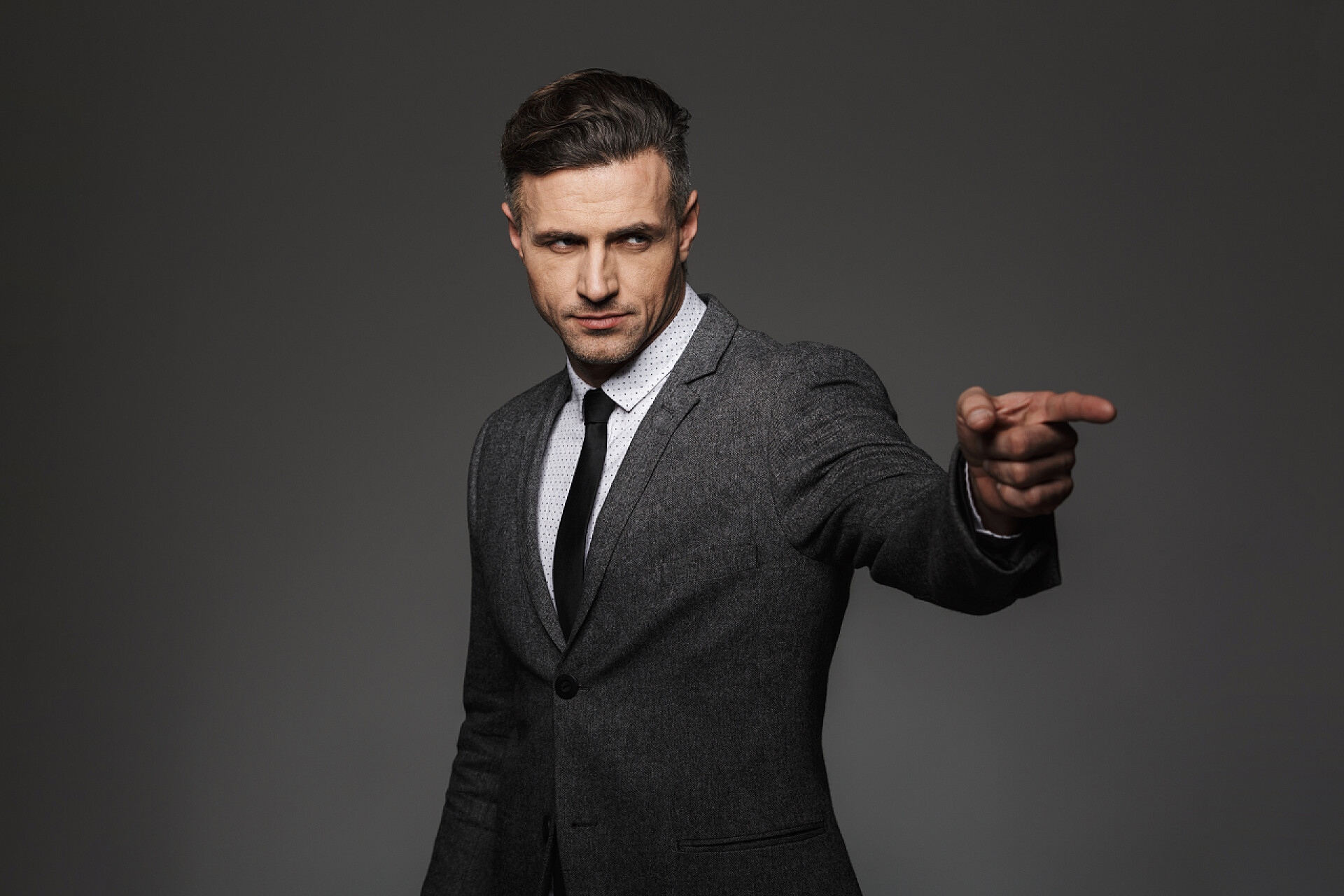 灰色背景上的商人30s. 商务套装和 t 的严格外观的商人照片