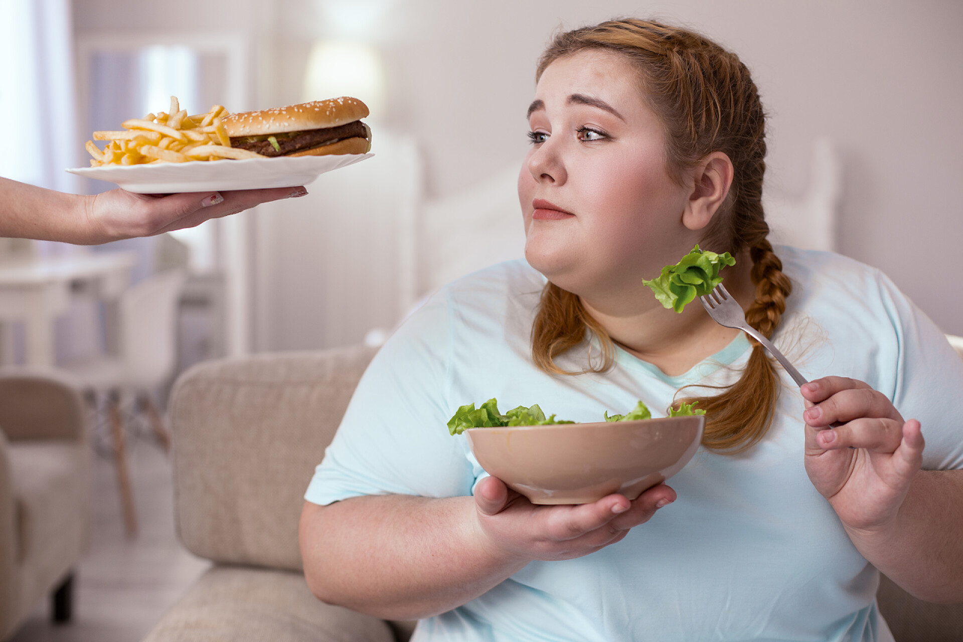 肥胖的女孩无法拒绝汉堡美味的汉堡包诱人的年轻女子