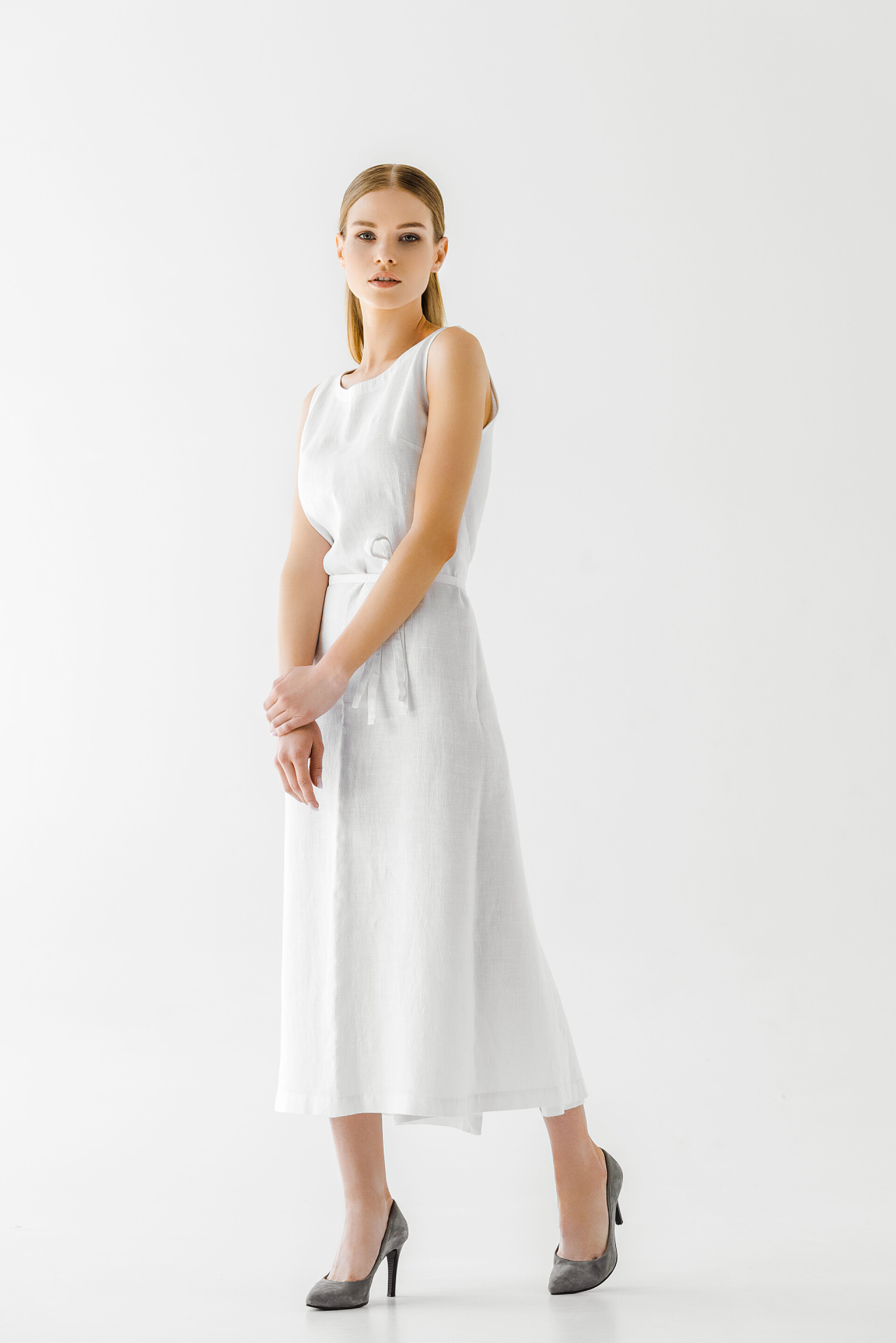 灰色背景前的美女模特灰色背景下的亚麻白裙造型美女模特 