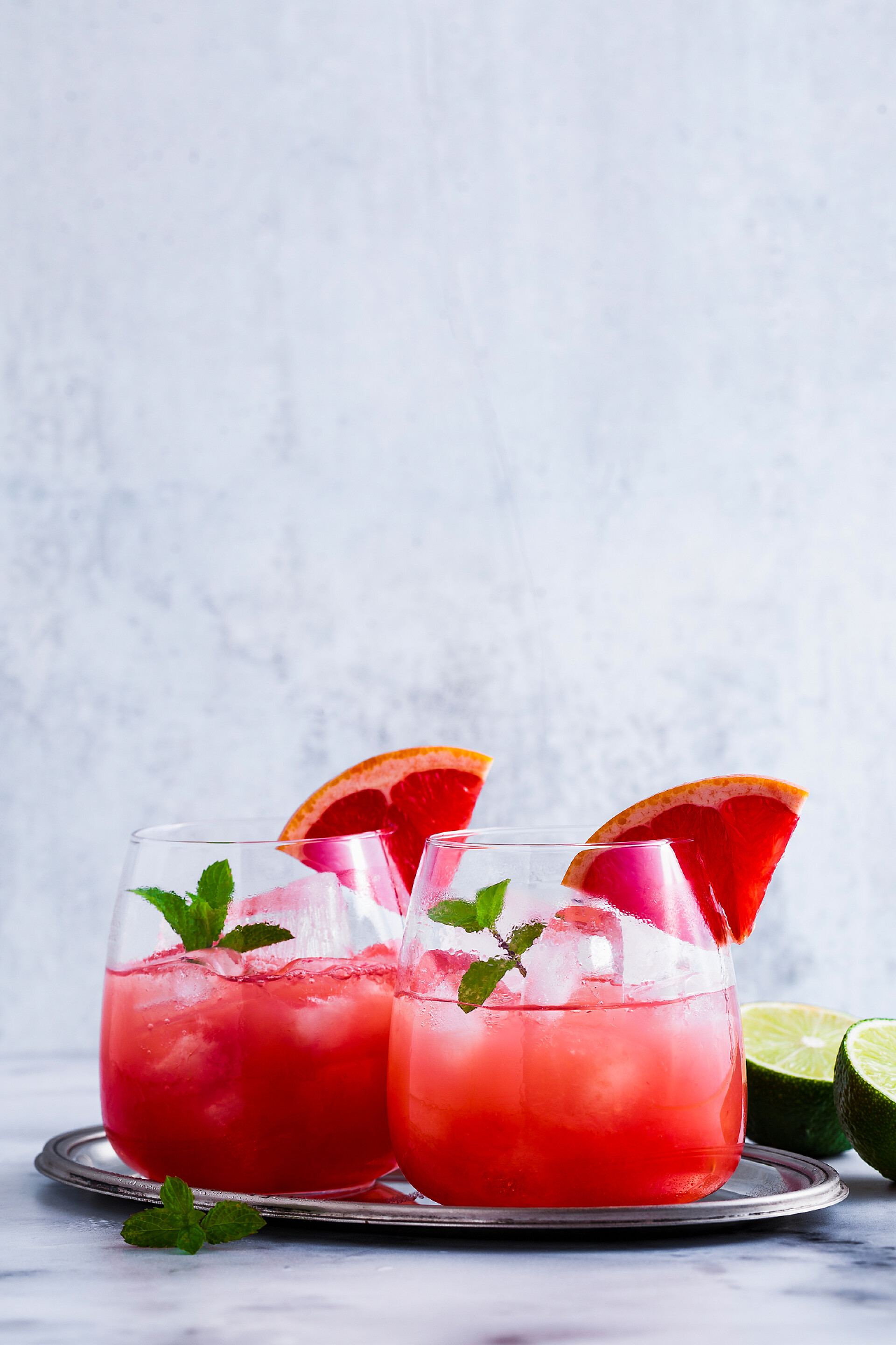 大理石桌上的柚子汁特写一张大理石桌上的柚子和冰杯的酒精鸡尾酒。柠檬汁提神饮料