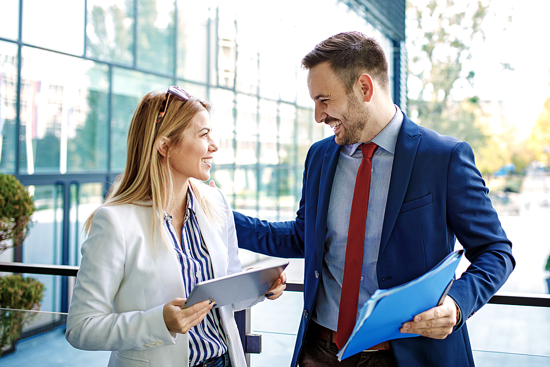 公司大楼前讨论新项目的商务人士年轻的商界人士在公司大楼前放松, 讨论新项目.