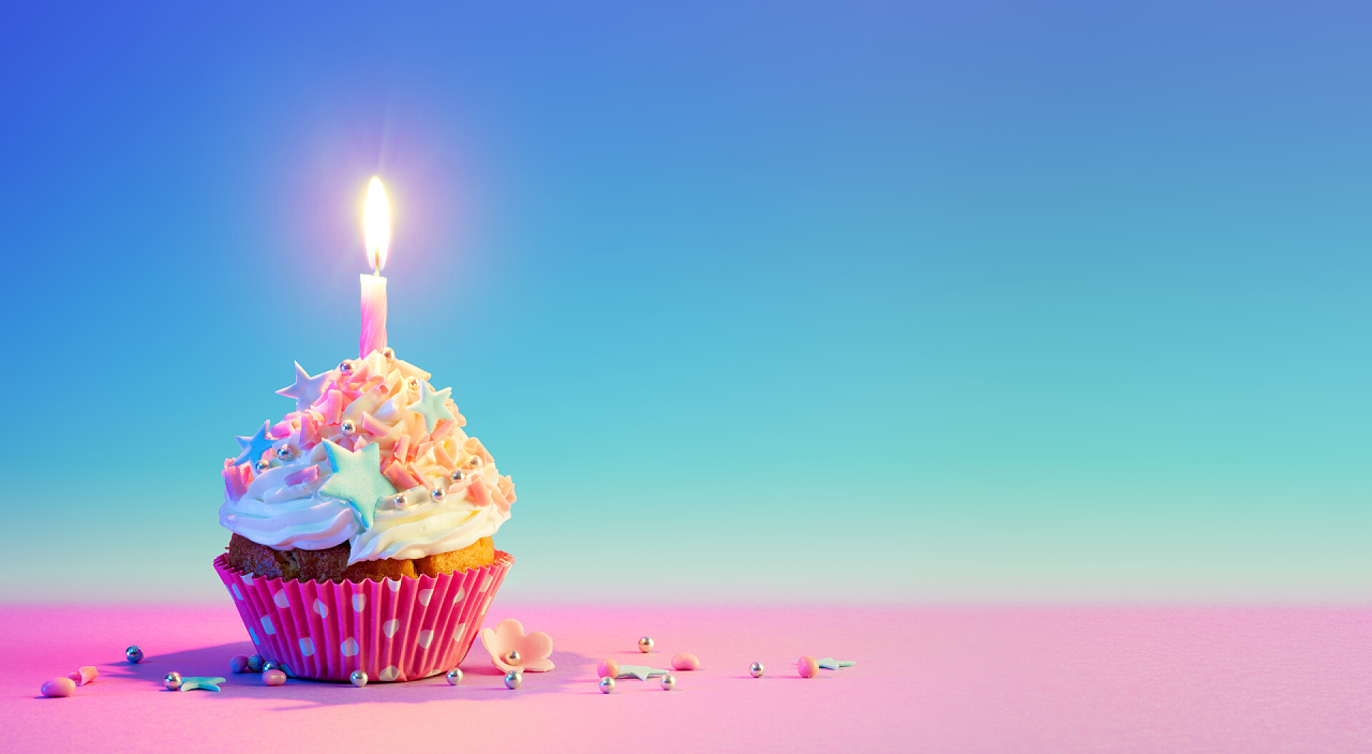 彩色背景上纸杯蛋糕中燃烧的蜡烛Birthday Cupcake With One Candle