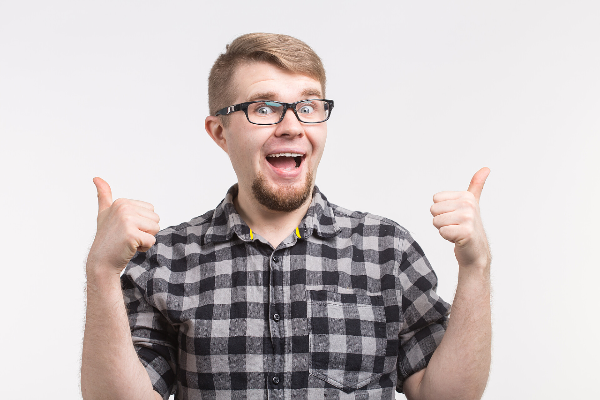 穿着格子衫竖大拇指的外国男人戴着格子衫的戴着大拇指的年轻滑稽男人的肖像