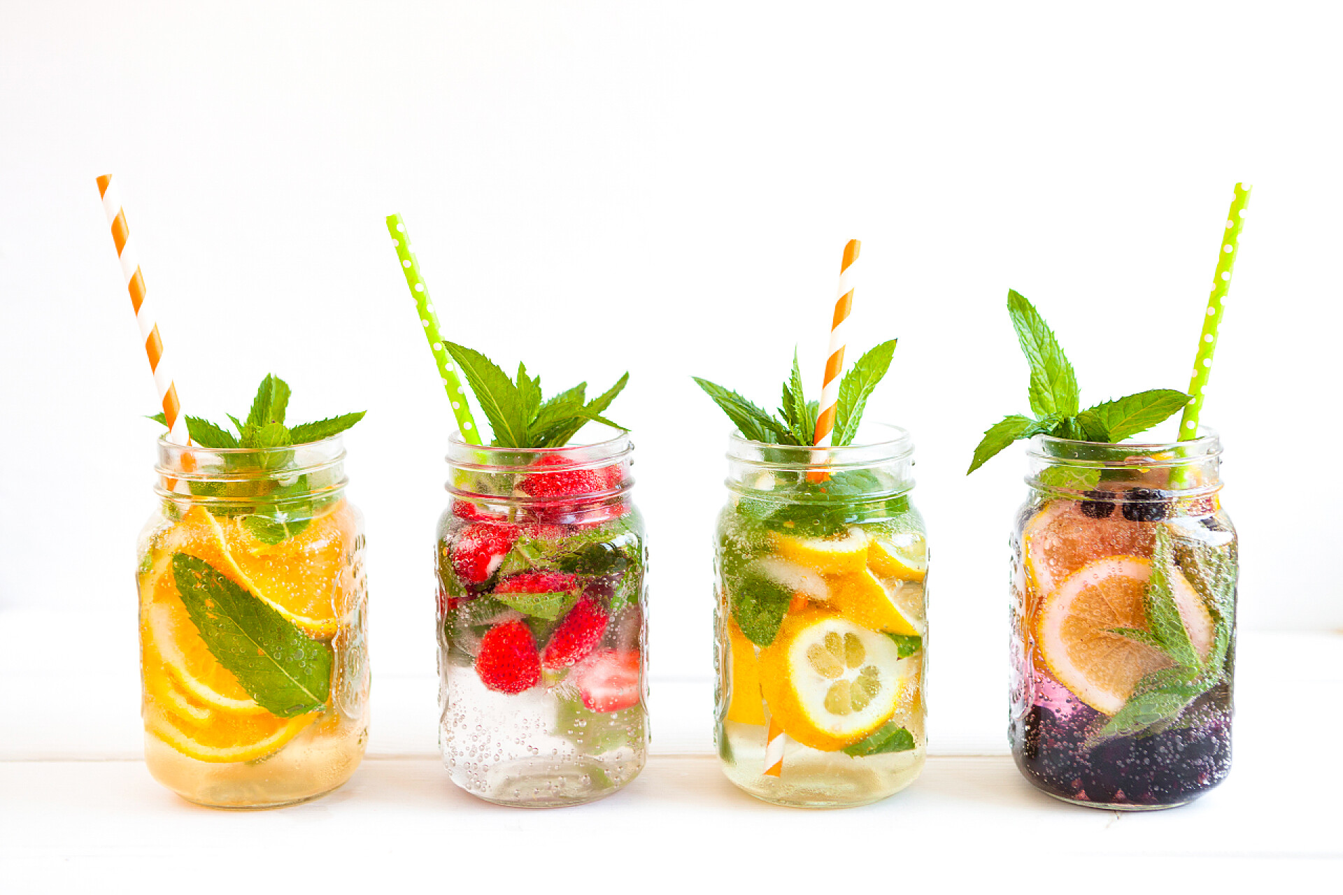 白色背景下玻璃杯中新鲜的果汁新鲜柠檬汁, 夏季水果和浆果在白色背景下