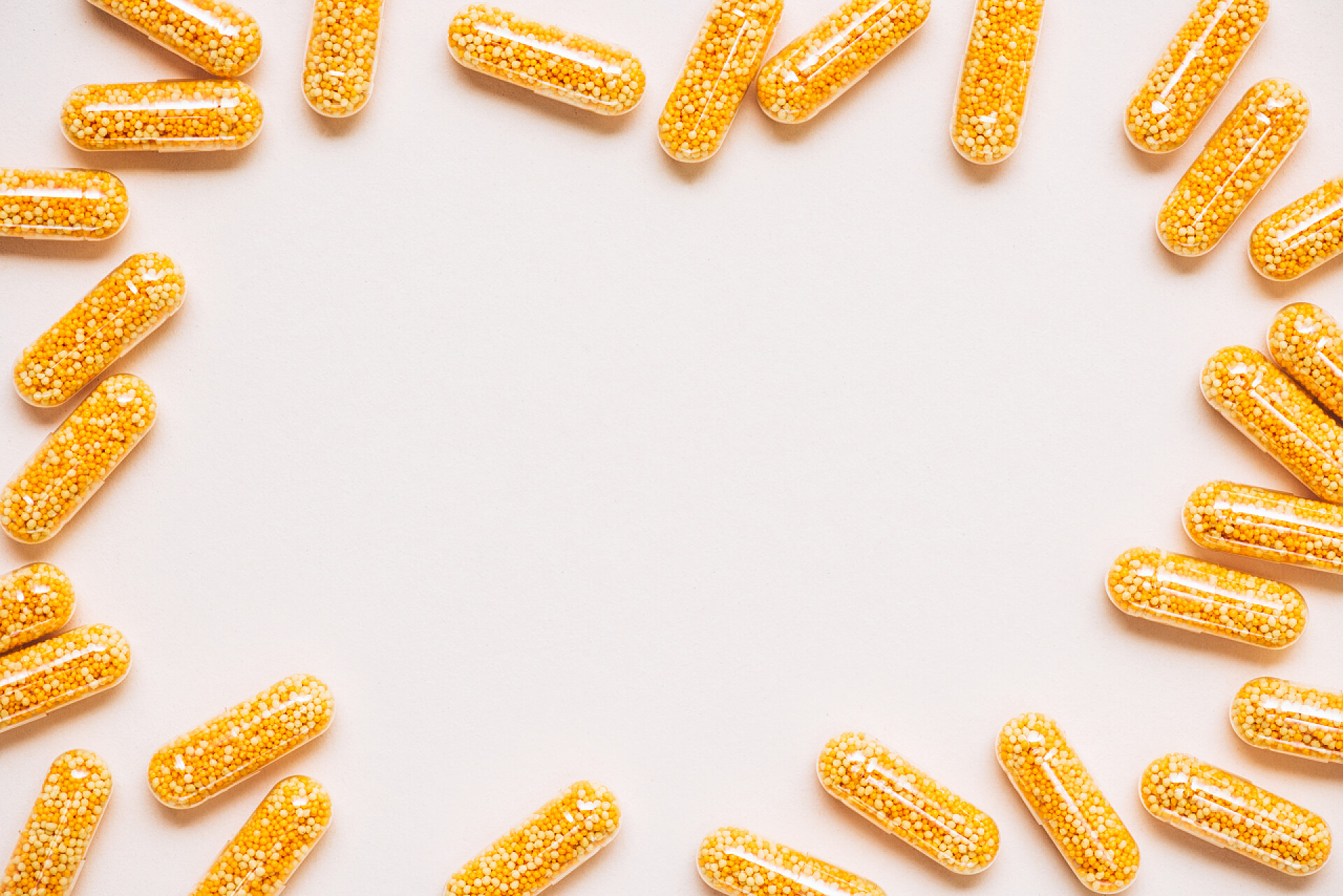 在白色背景上的黄色胶囊黄色医用胶囊在白色框架上的顶部视图