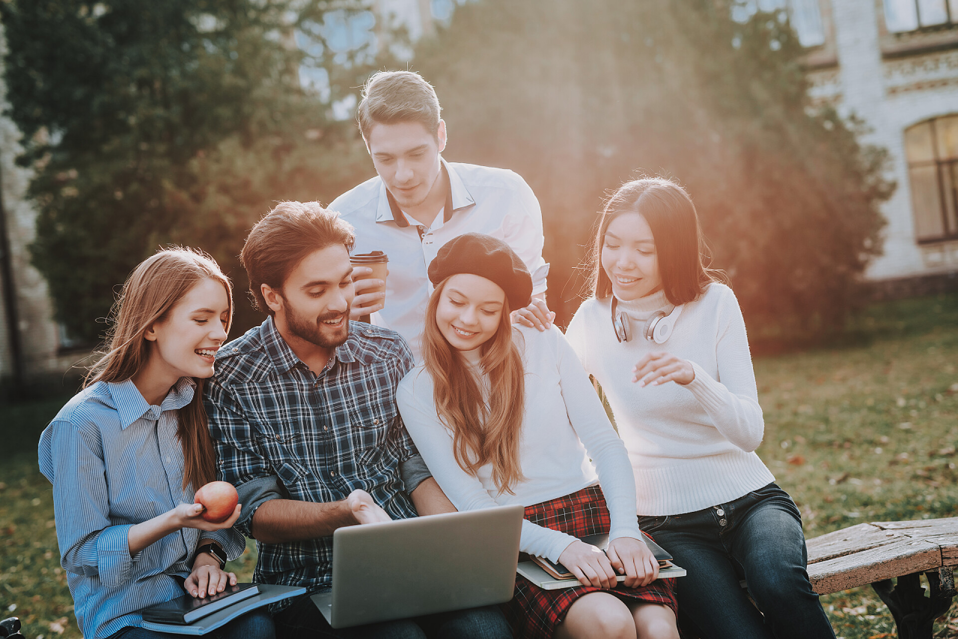 一起用笔记本电脑学习的大学生青年团体。坐。自由。时髦。知识。建筑。庭院。大学。学生。一起学习。心情很好笔记本 电脑。教科书。玩得愉快。笔记本。友谊.