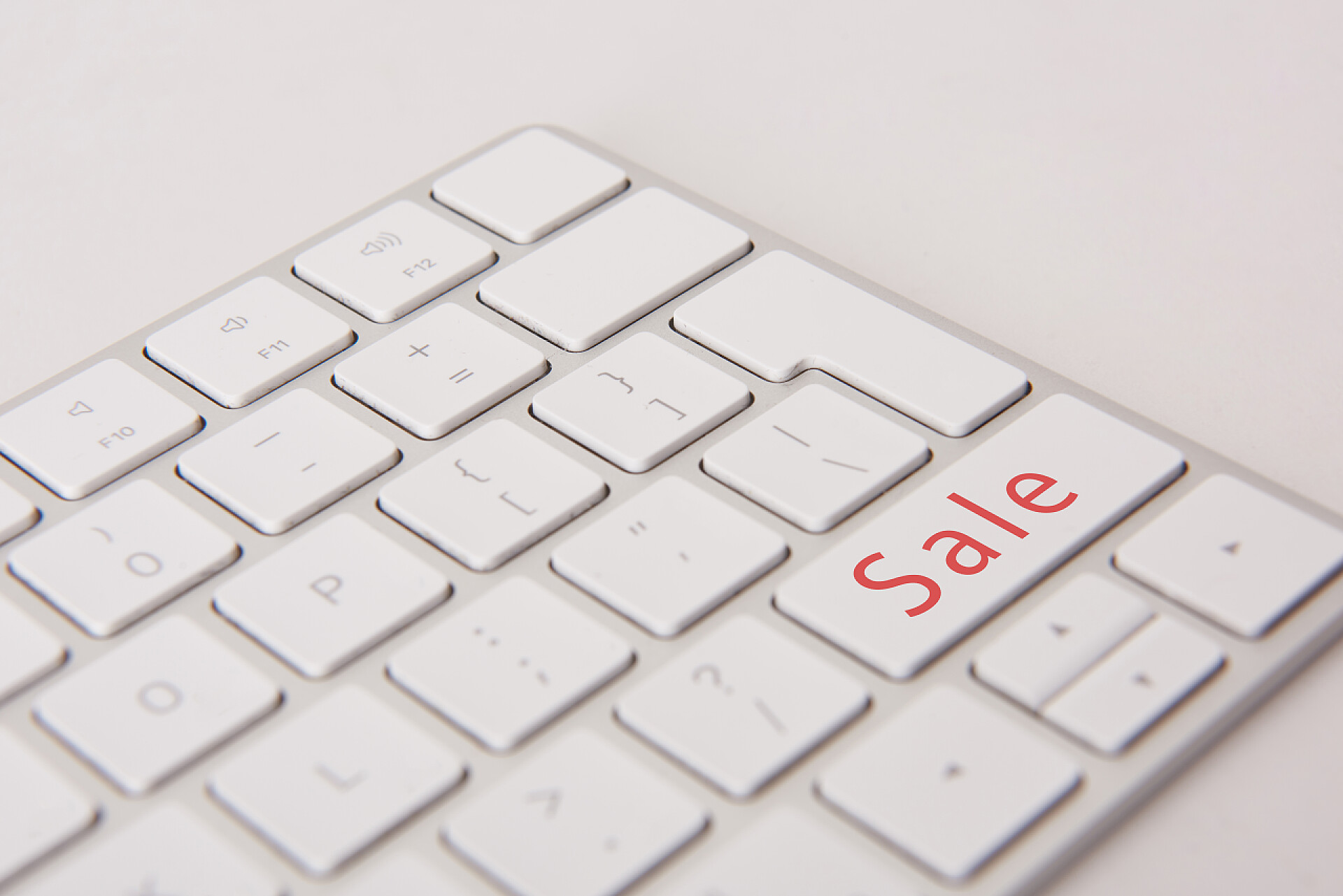 灰色背景的白色键盘计算机键盘特写镜头黑色星期五按钮查出白色