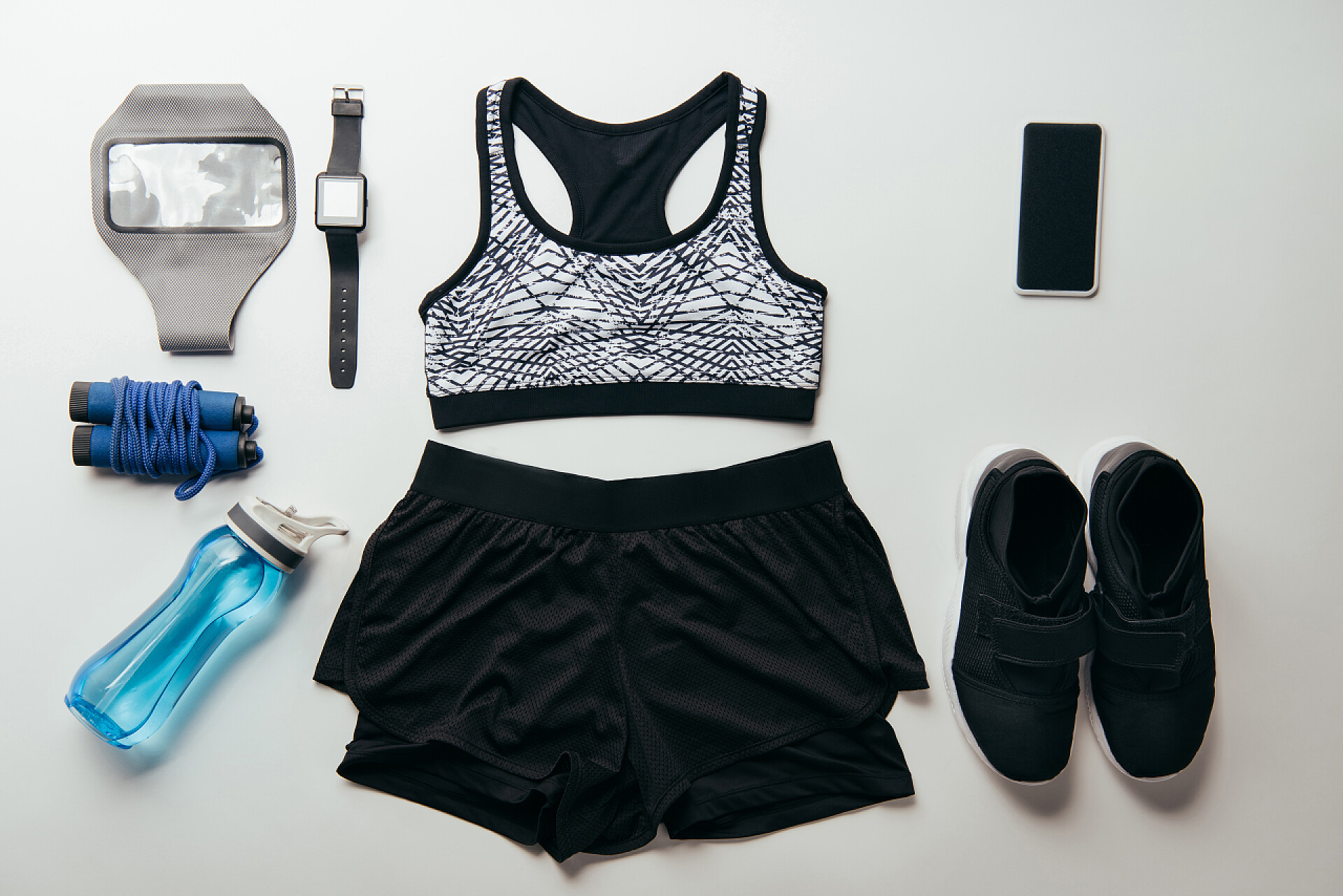 一套运动服和一些运动设备从上面的安排集运动器材隔离在白色上的看法