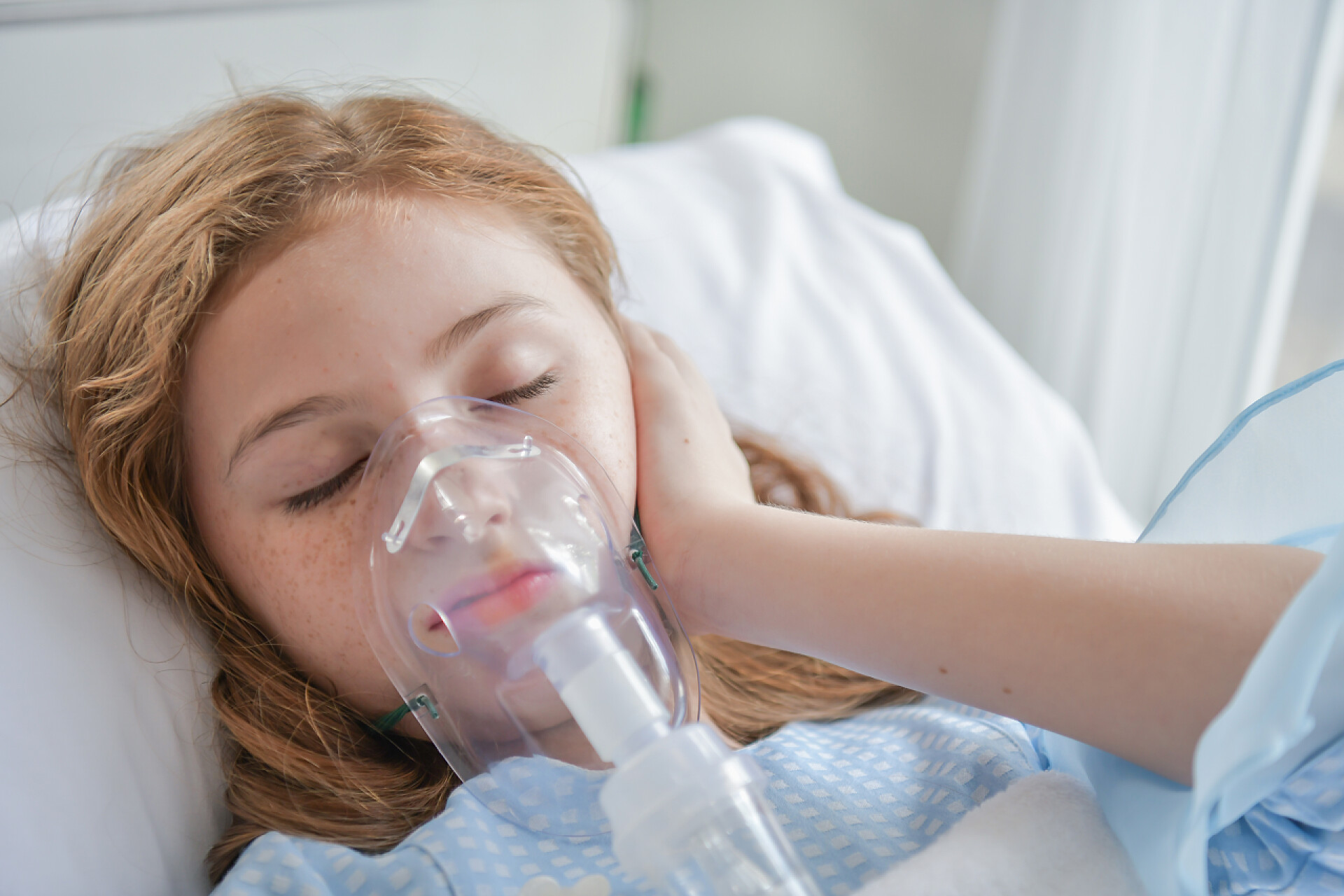 年轻女孩带着氧气面罩躺在医院病床上健康概念。小孩子病得很厉害。小孩子在医院里压力很大。.