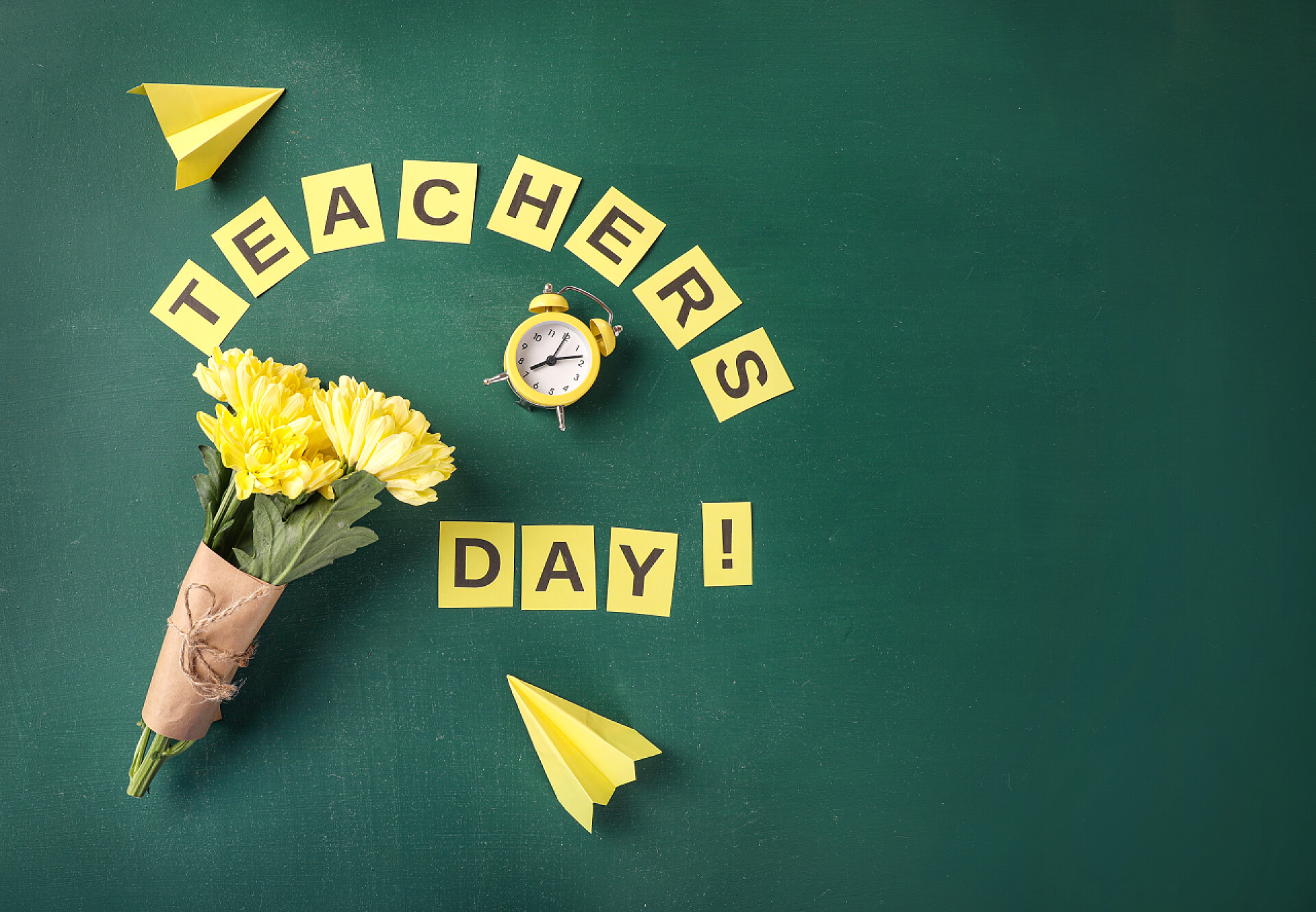 绿色背景一束鲜花教师节贺卡,绿色黑板背景.顶部视图.