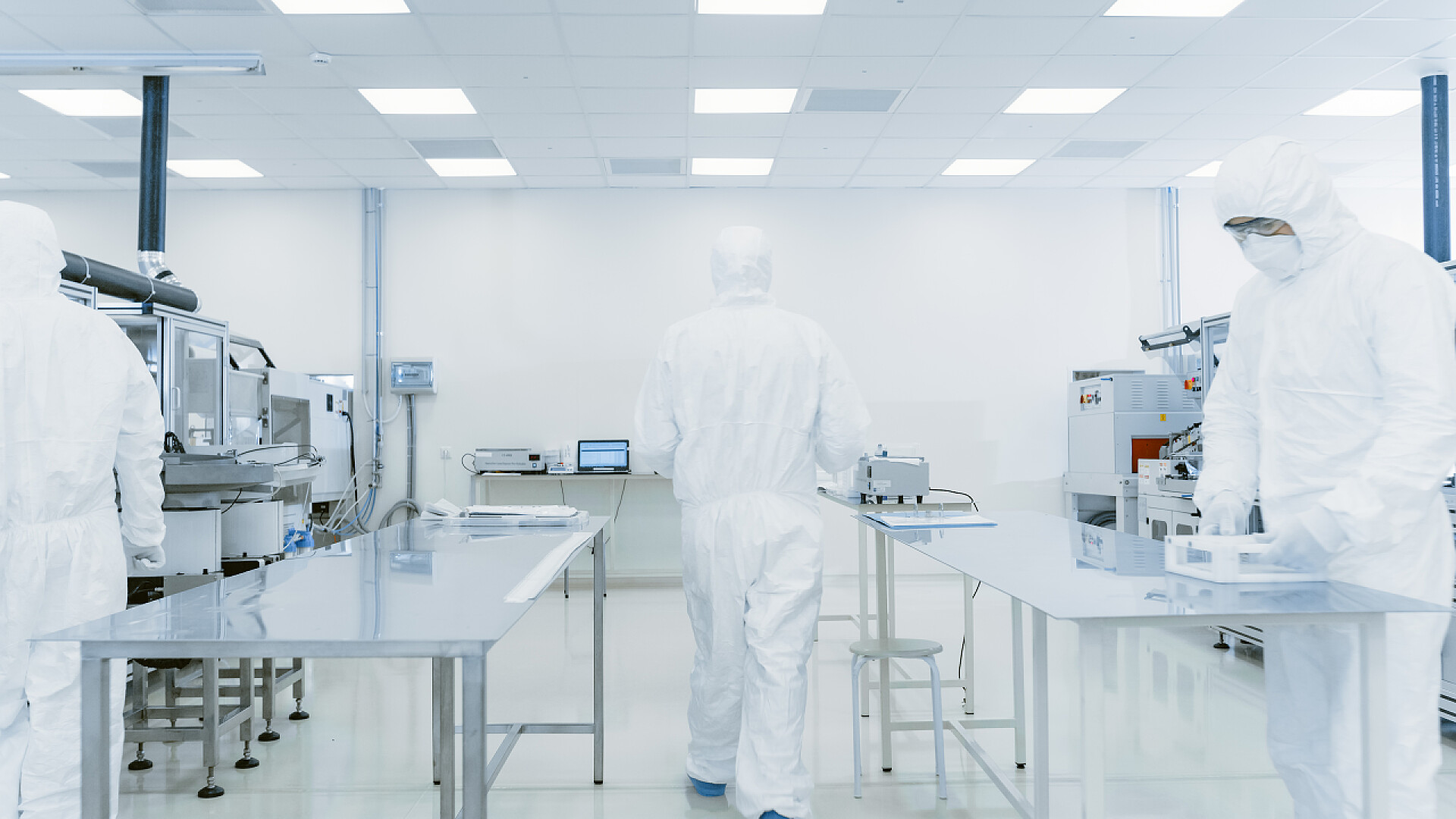 穿着防护服在实验室工作的人通过实验室,从事成品防护服包装工作的科学家.现代工业机械工厂的工人。产品制造工艺：制药、半导体