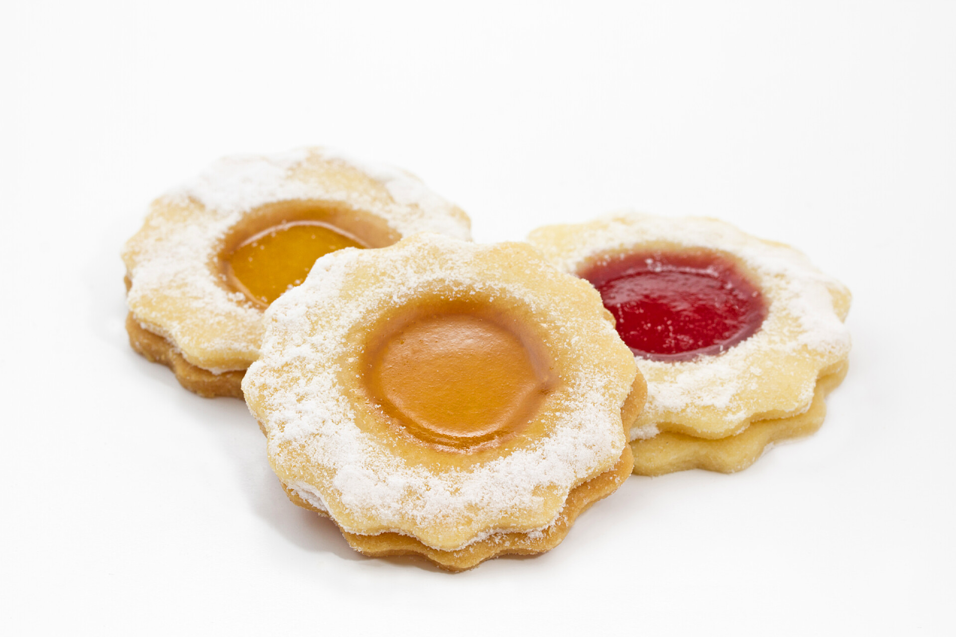 放在白色背景的果酱花朵饼干覆盆子果酱的美味圣诞饼干