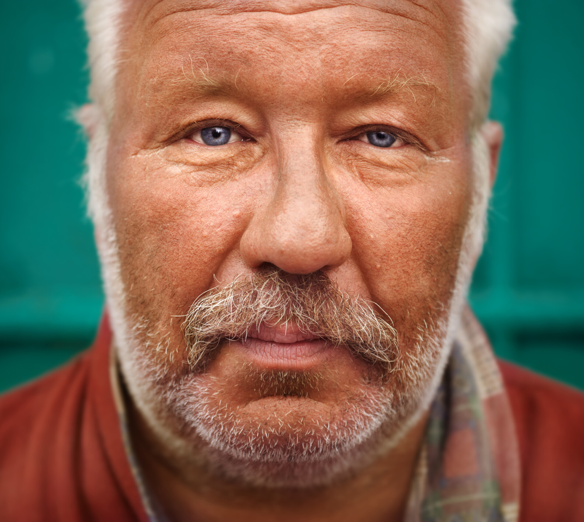 绿色墙体前的老年人五官无家可归的人