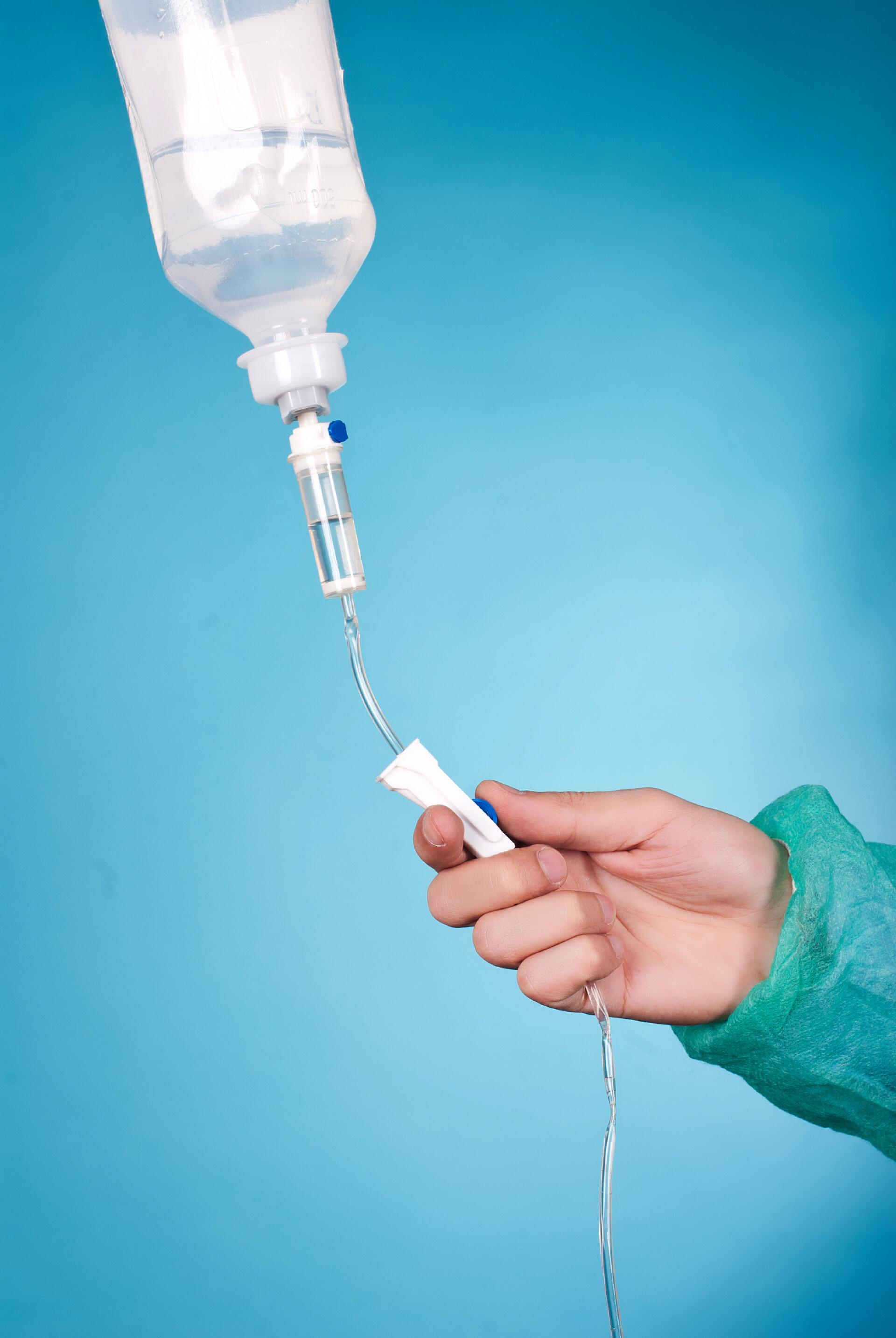蓝色背景下调点滴的手手和输液瓶