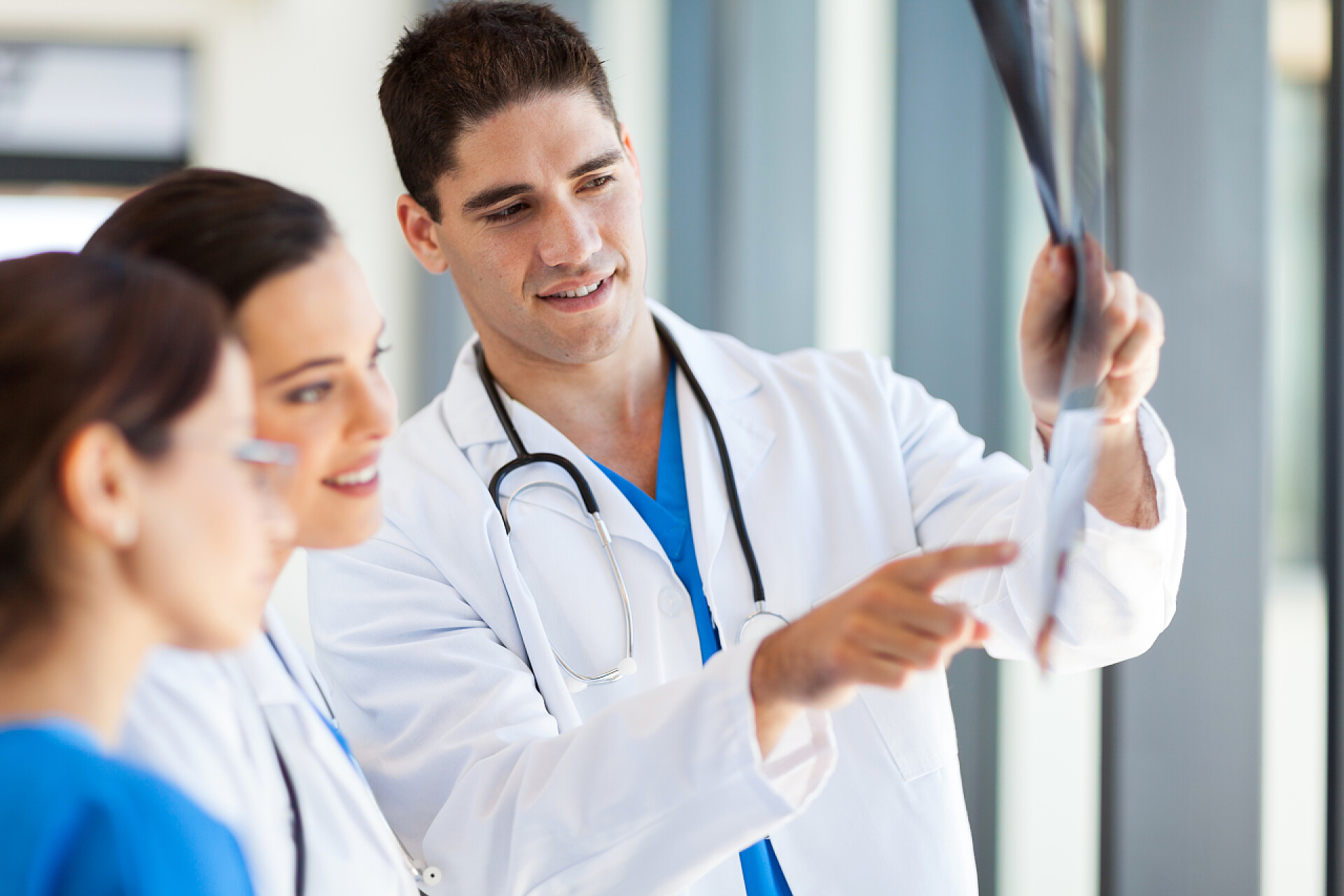 医务人员分析病人的X光射线结果图看着病人的 x 光胶片的医务工作者的组