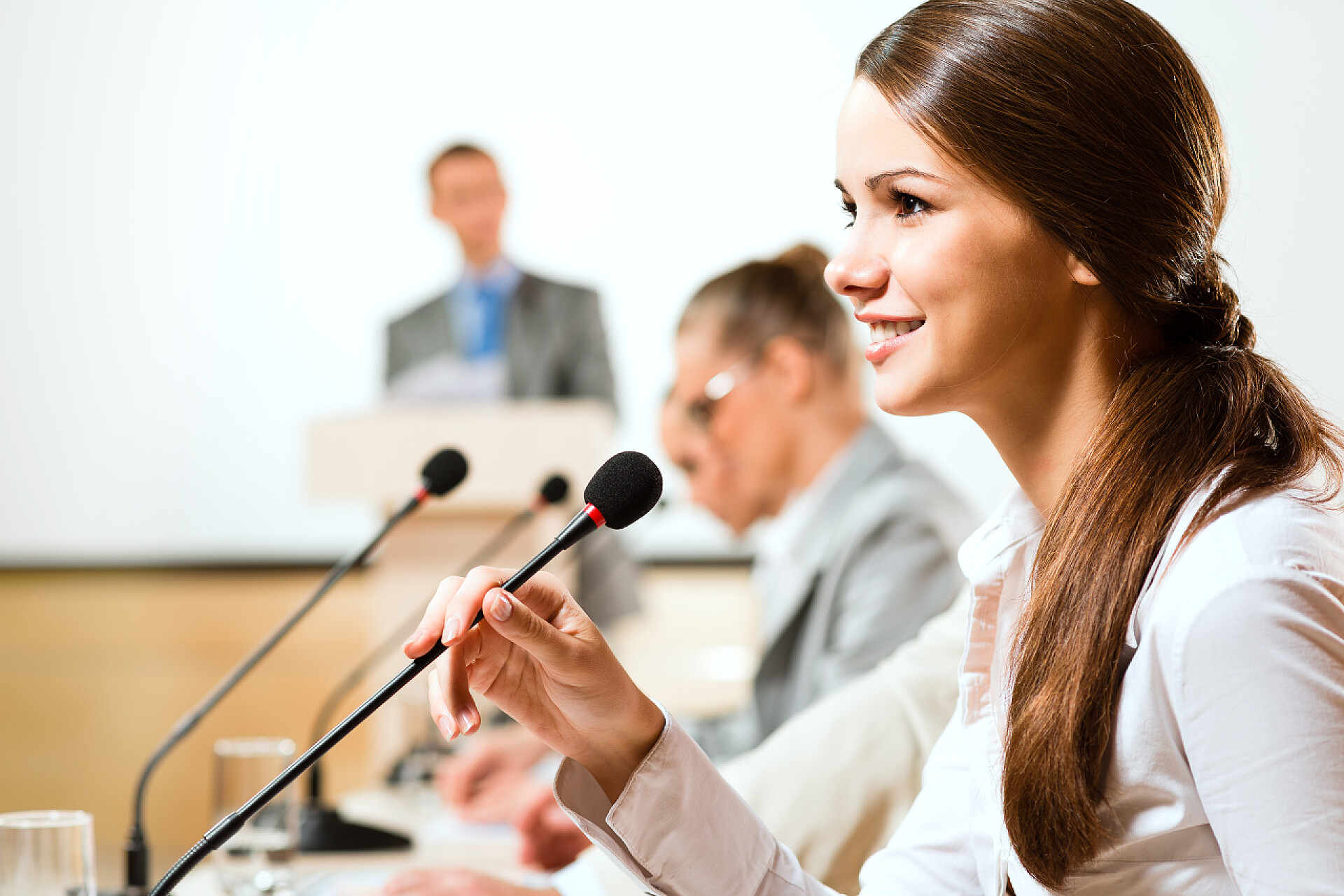 在会议上女商人用麦克风讲话obchodní žena mluví do mikrofonu