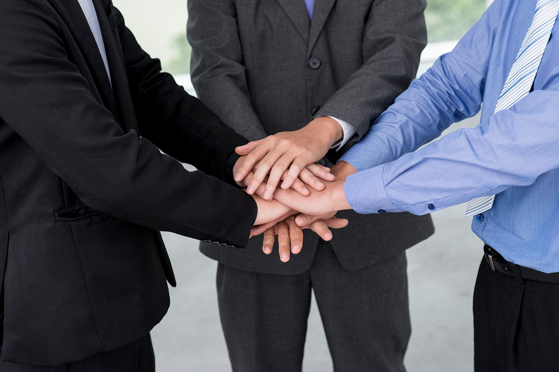 商务人士手堆手合作年轻人在小组治疗会议上举手，底部视图