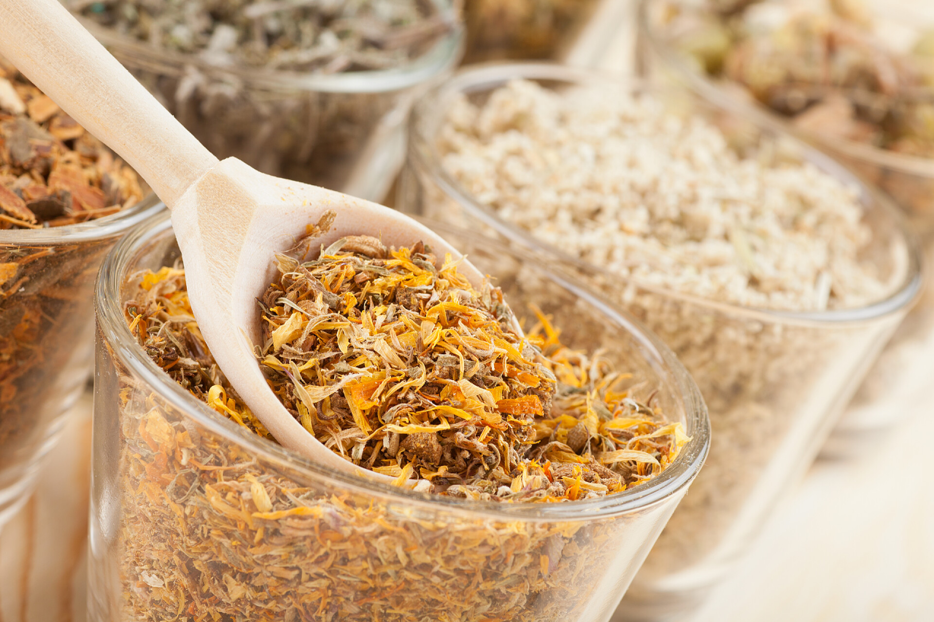 装在玻璃杯里面的花茶在玻璃杯子和木勺，中药草药治疗