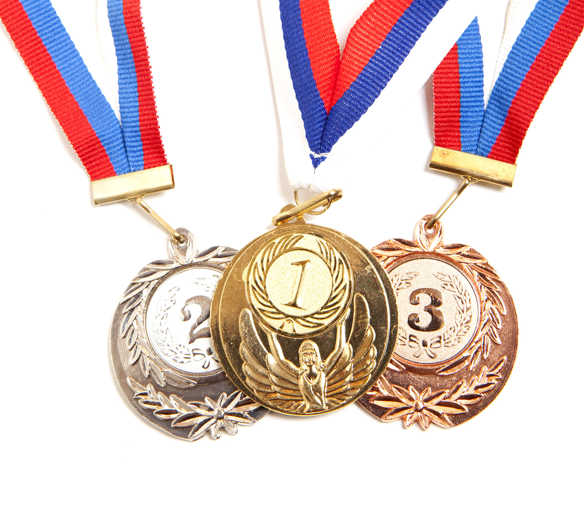 白色背景上的金银铜牌特写金属奖牌与三色丝带