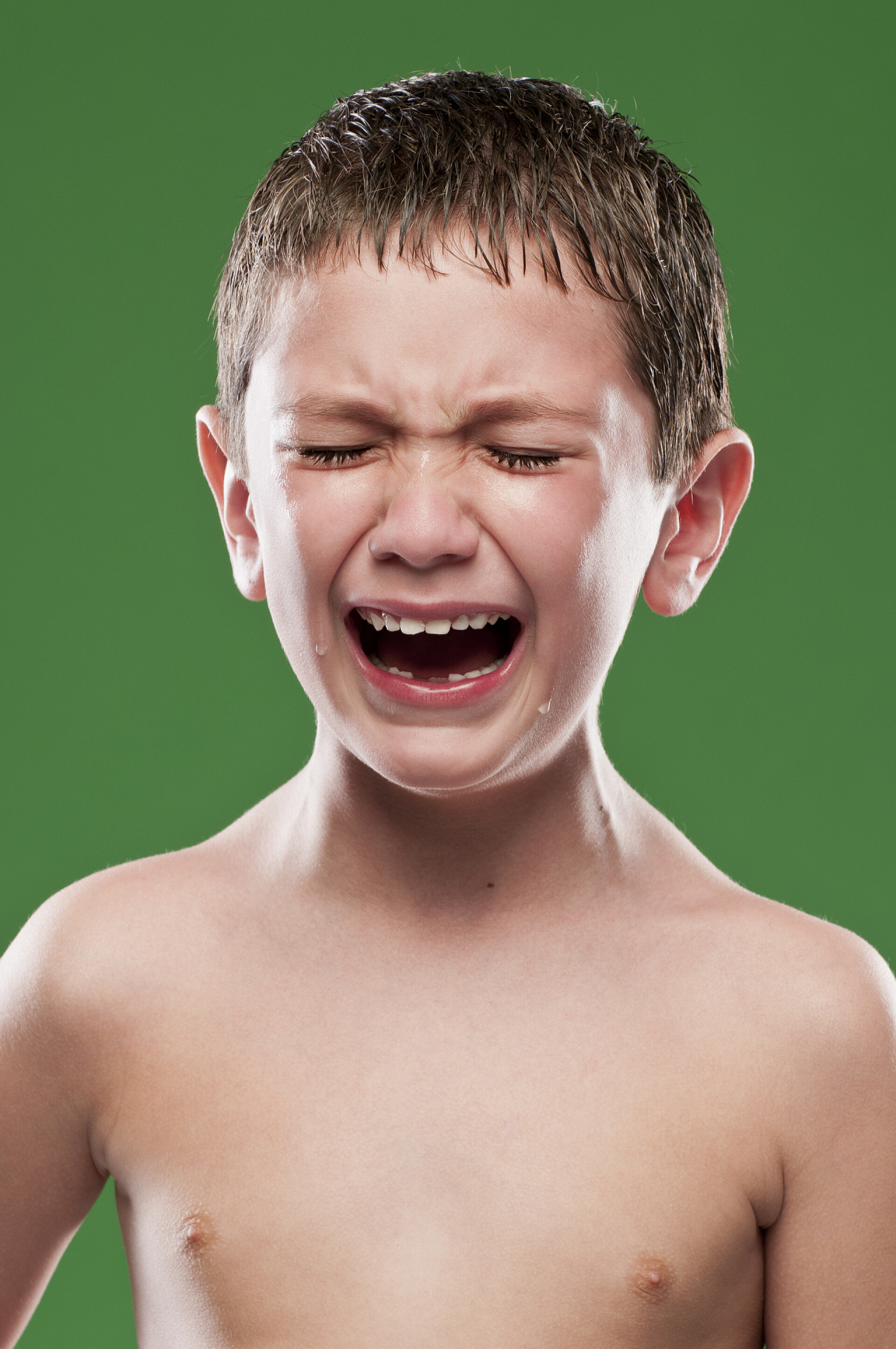 绿色背景中痛苦哭泣的小男孩男孩痛苦地哭