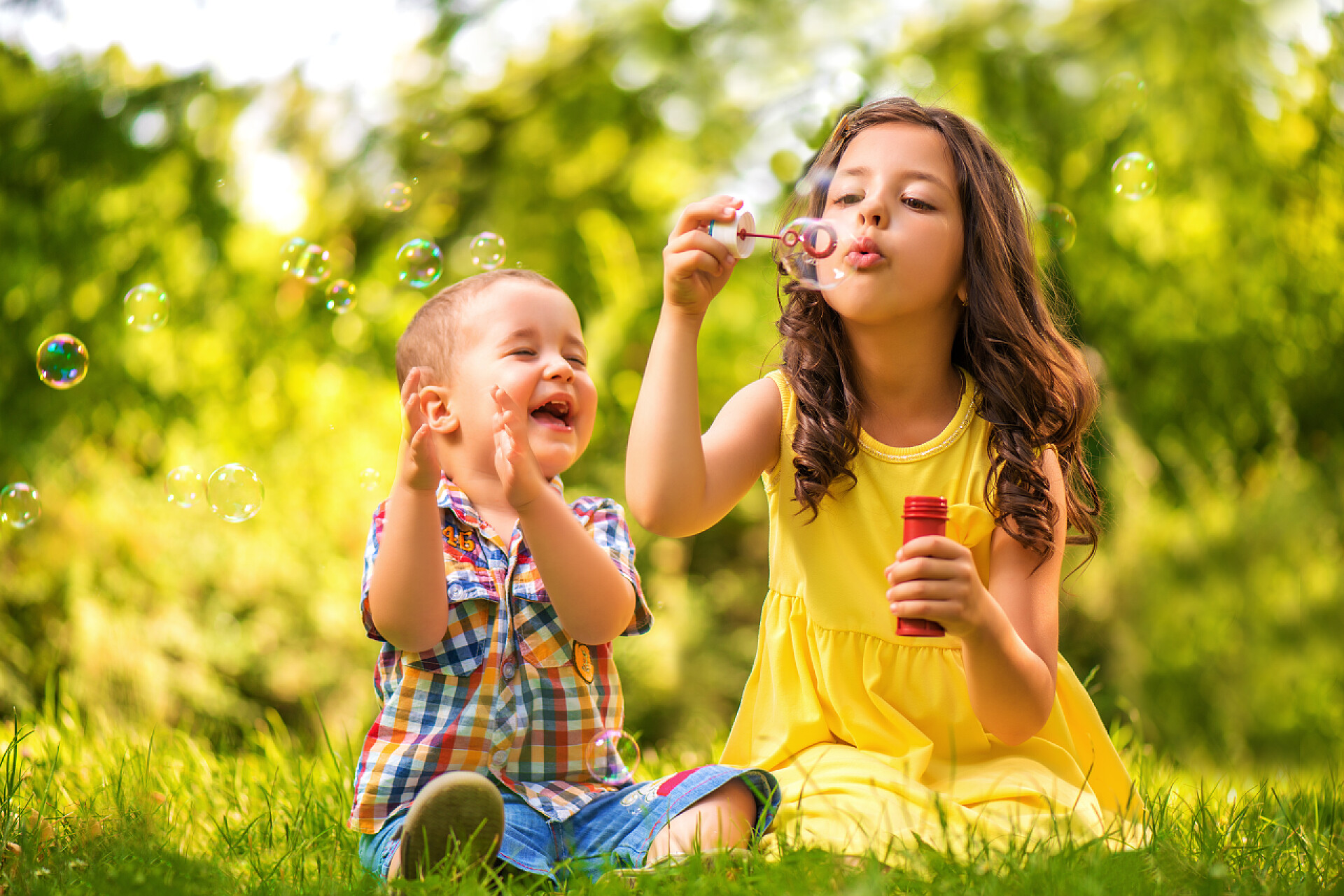 可爱的孩子们在公园玩吹泡泡小女孩和男孩玩肥皂泡
