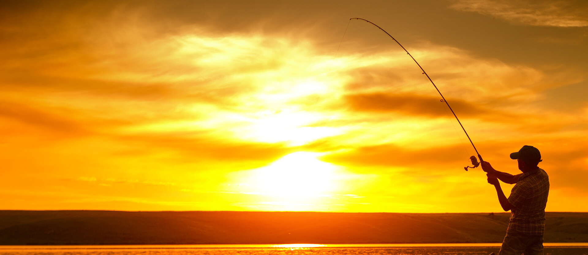 男人日落时分在池塘钓鱼渔民
