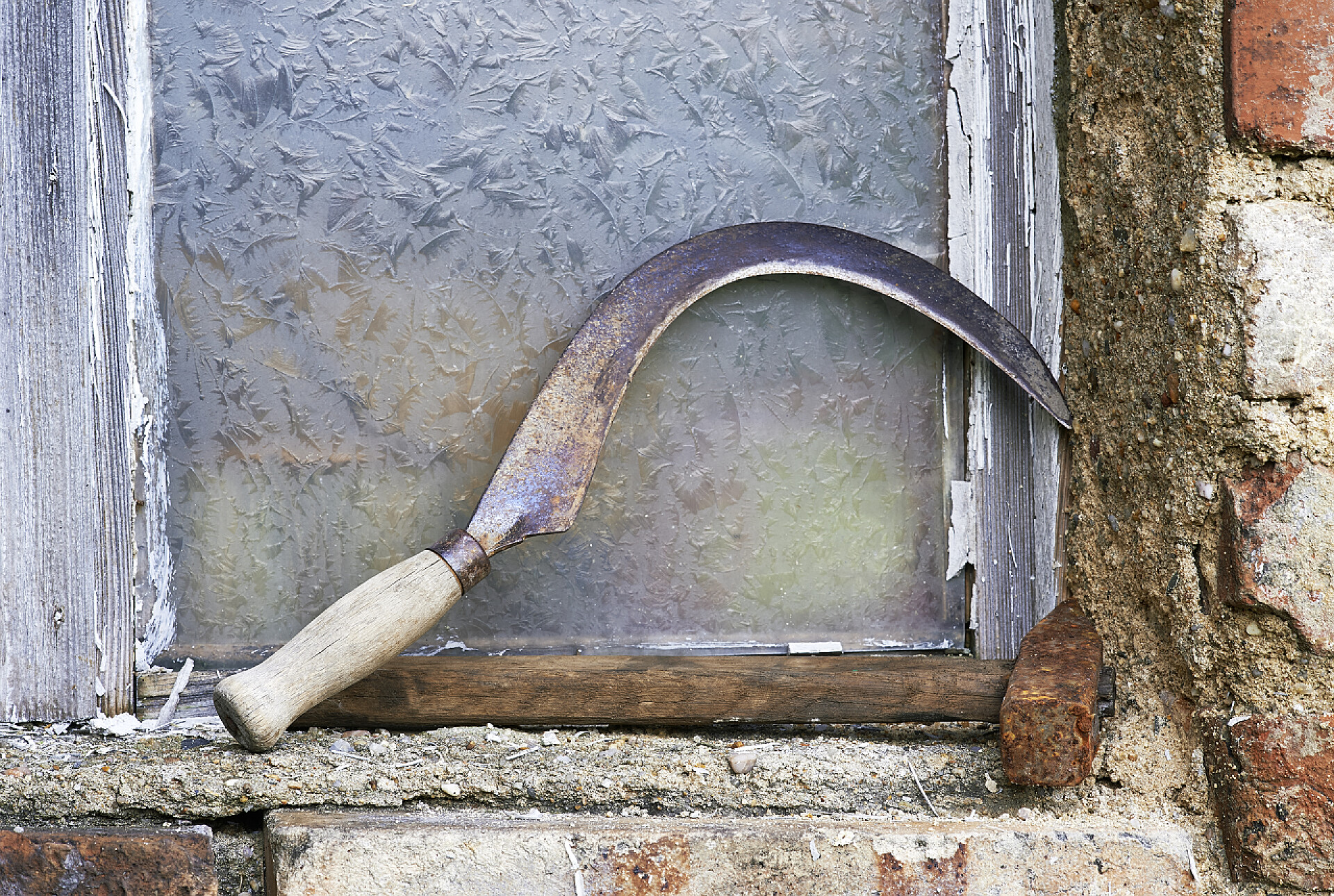 一个竖直放置在墙面的镰刀老锤