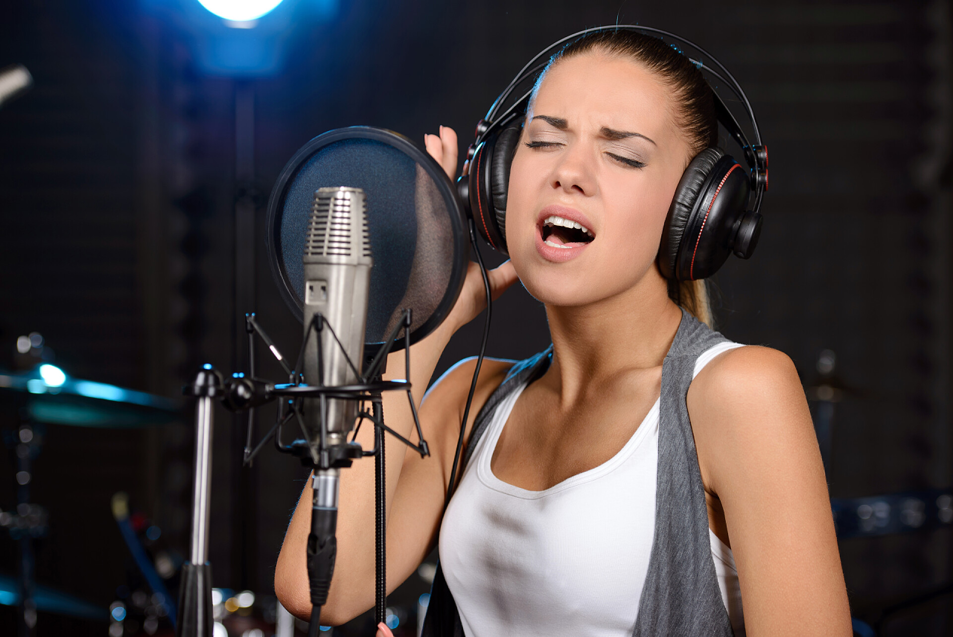 在专业演播室录制歌曲的年轻女子录音室