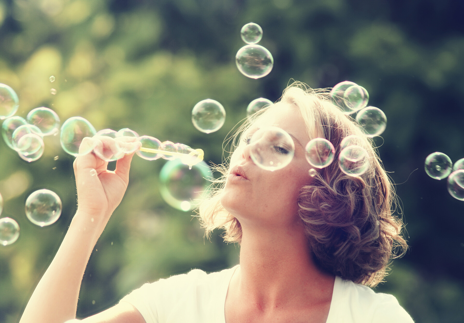 一个美丽的女人在公园里吹泡泡美丽的女人吹泡泡