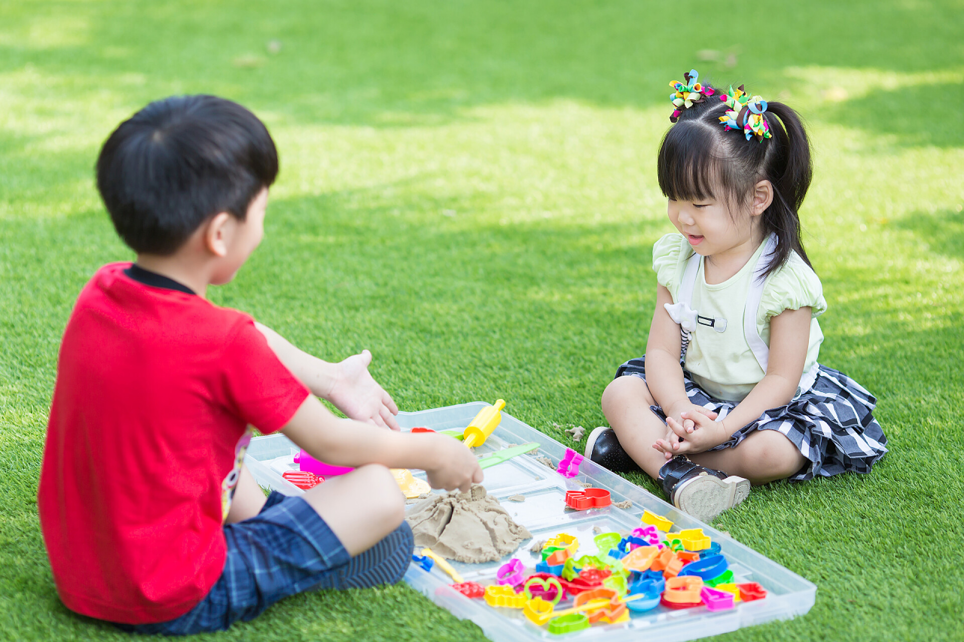 弟弟和妹妹在草地上玩积木弟弟和妹妹玩沙