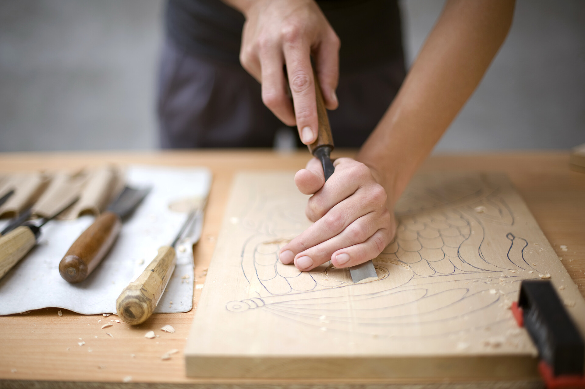 艺术家在专心的做木雕与艺术家木雕在桌子上