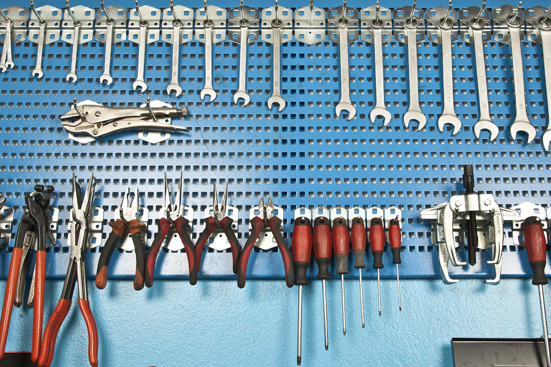 不同的汽车修理工具设置在墙上夹扭钳和螺丝起子的特写