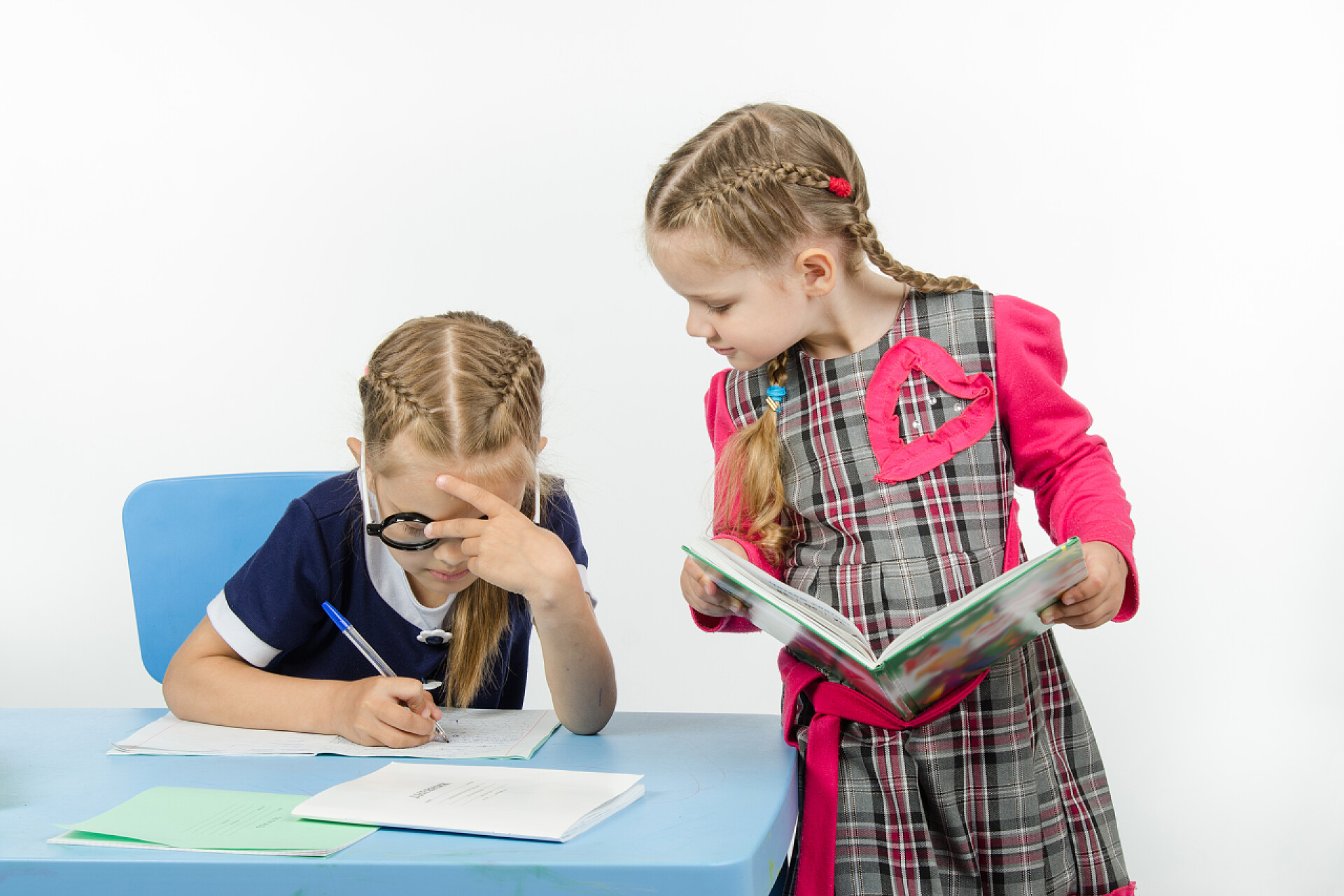 在做作业的两个女孩两个女孩在学校执行某项任务