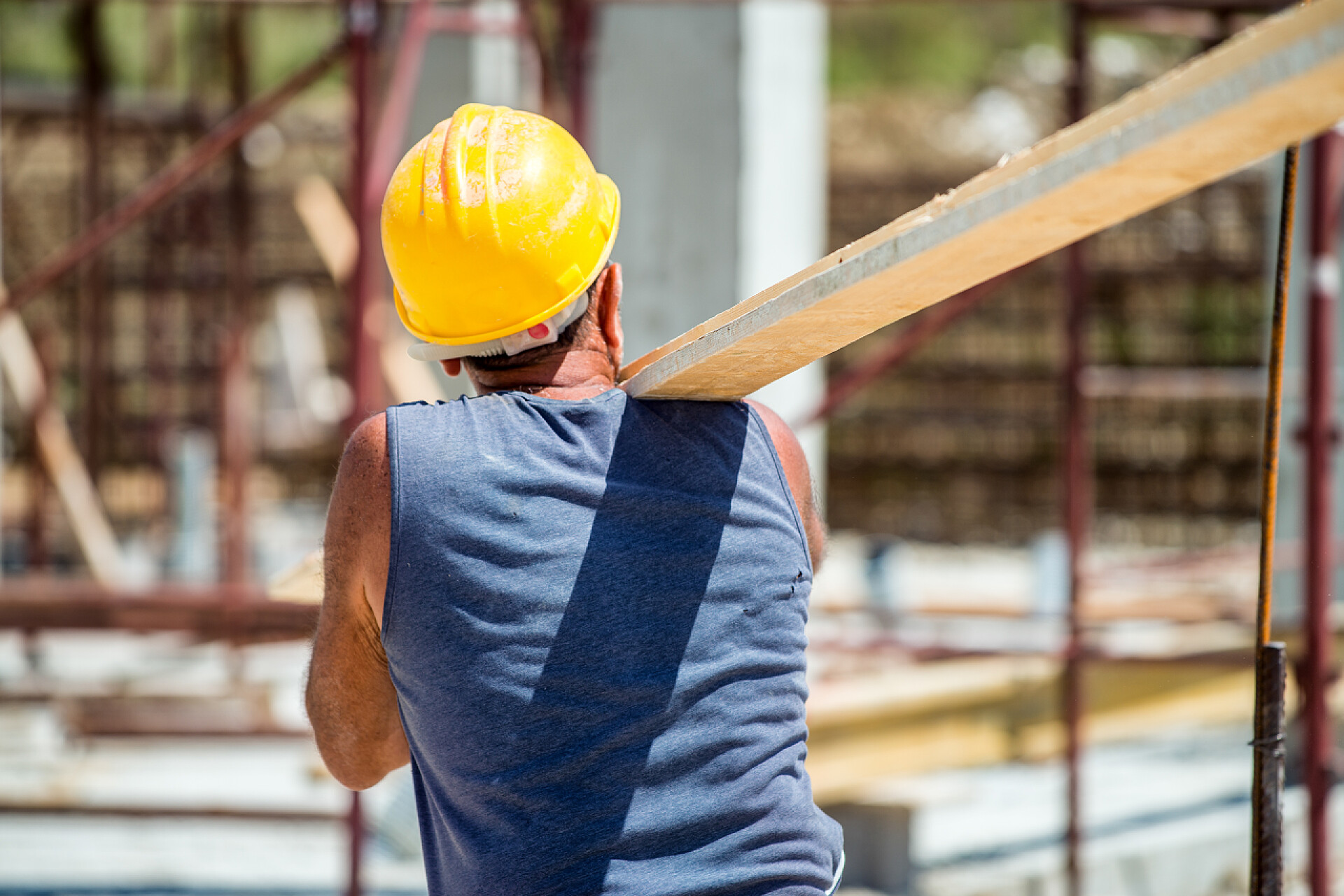 工人在建筑工地运输木板在施工现场工人