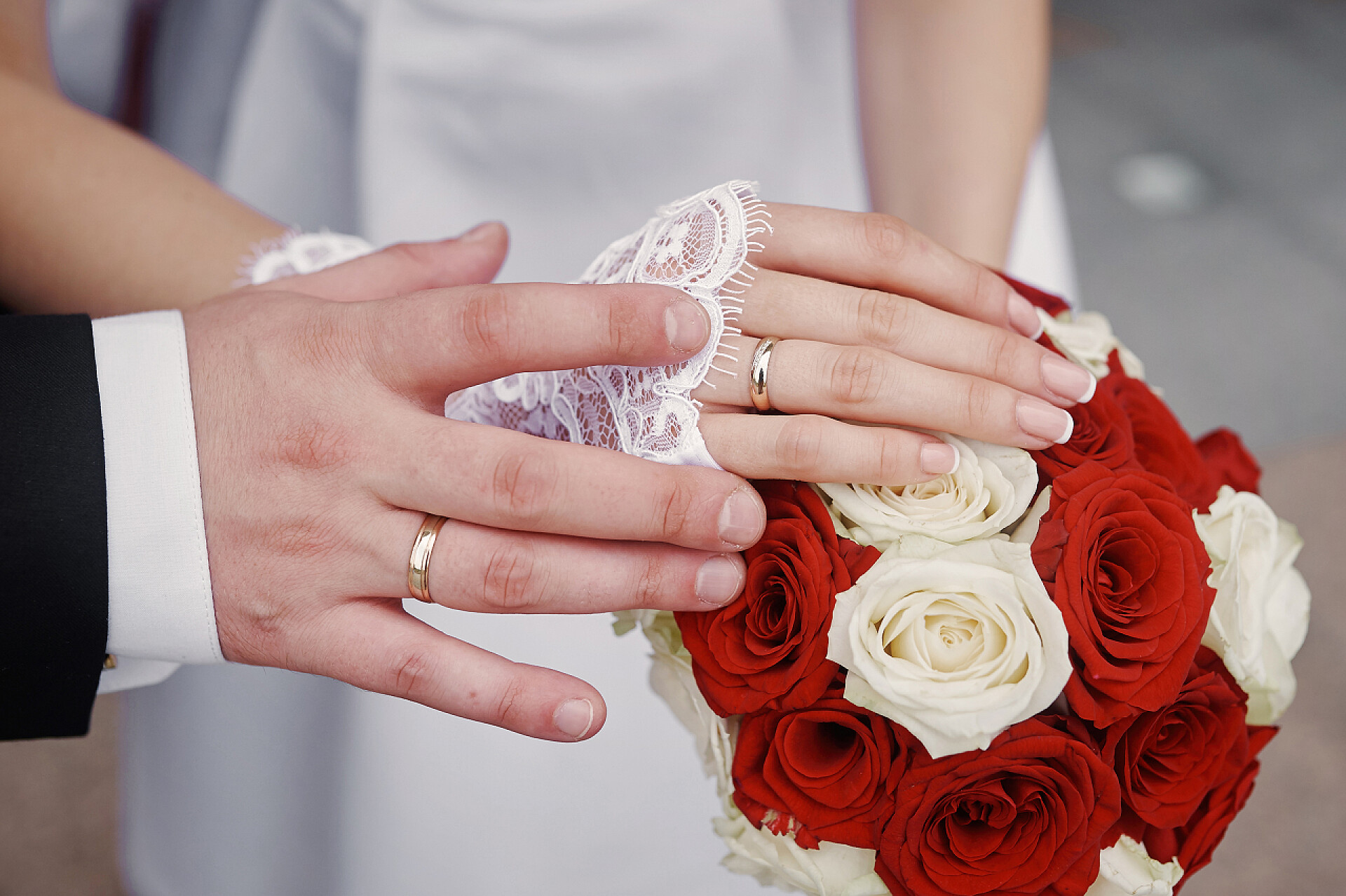 新婚夫妇举办婚礼金戒指新娘和新郎在婚礼花束的双手