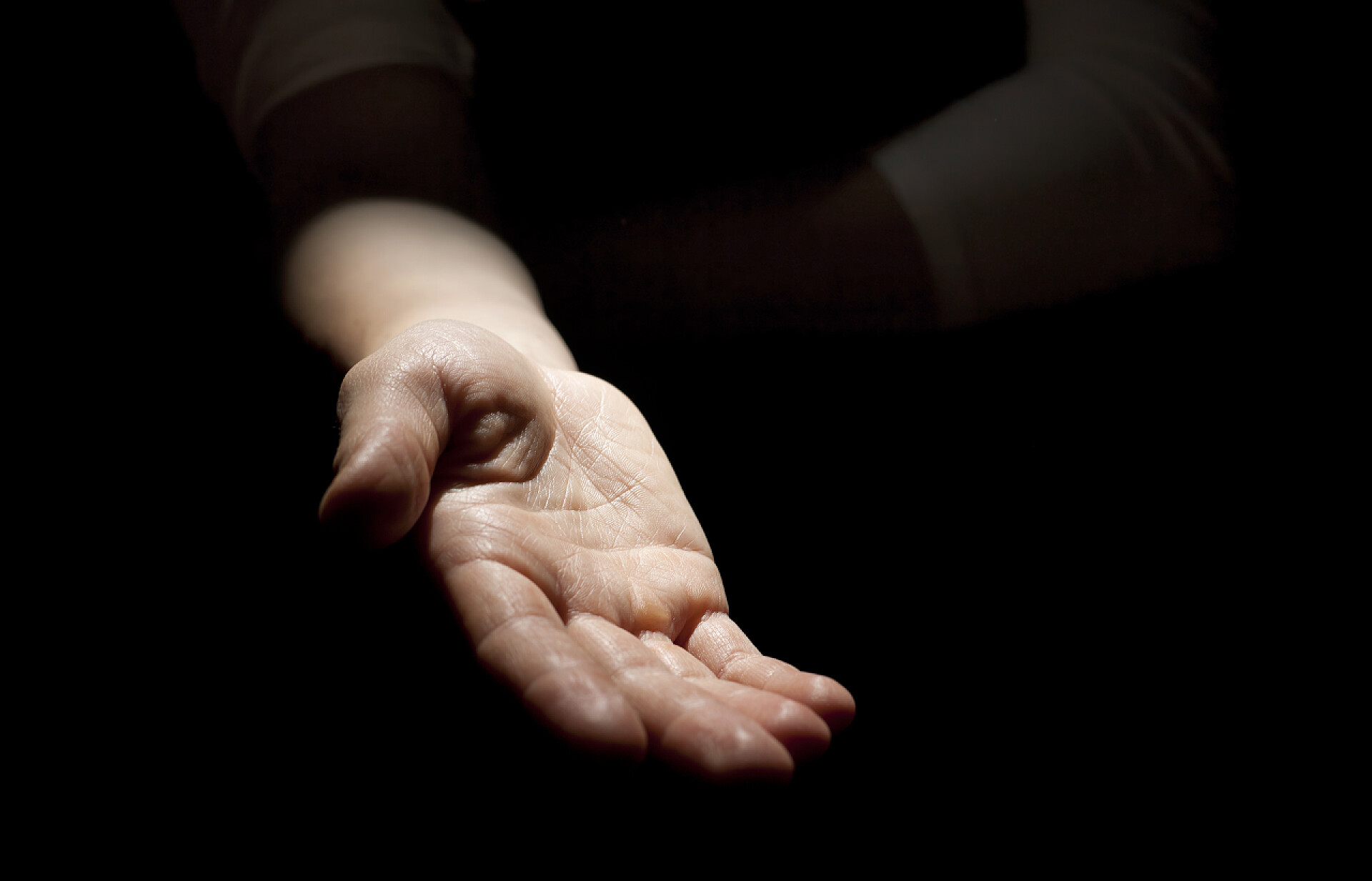 黑色背景中伸出一只手寻求帮助寻求帮助的手