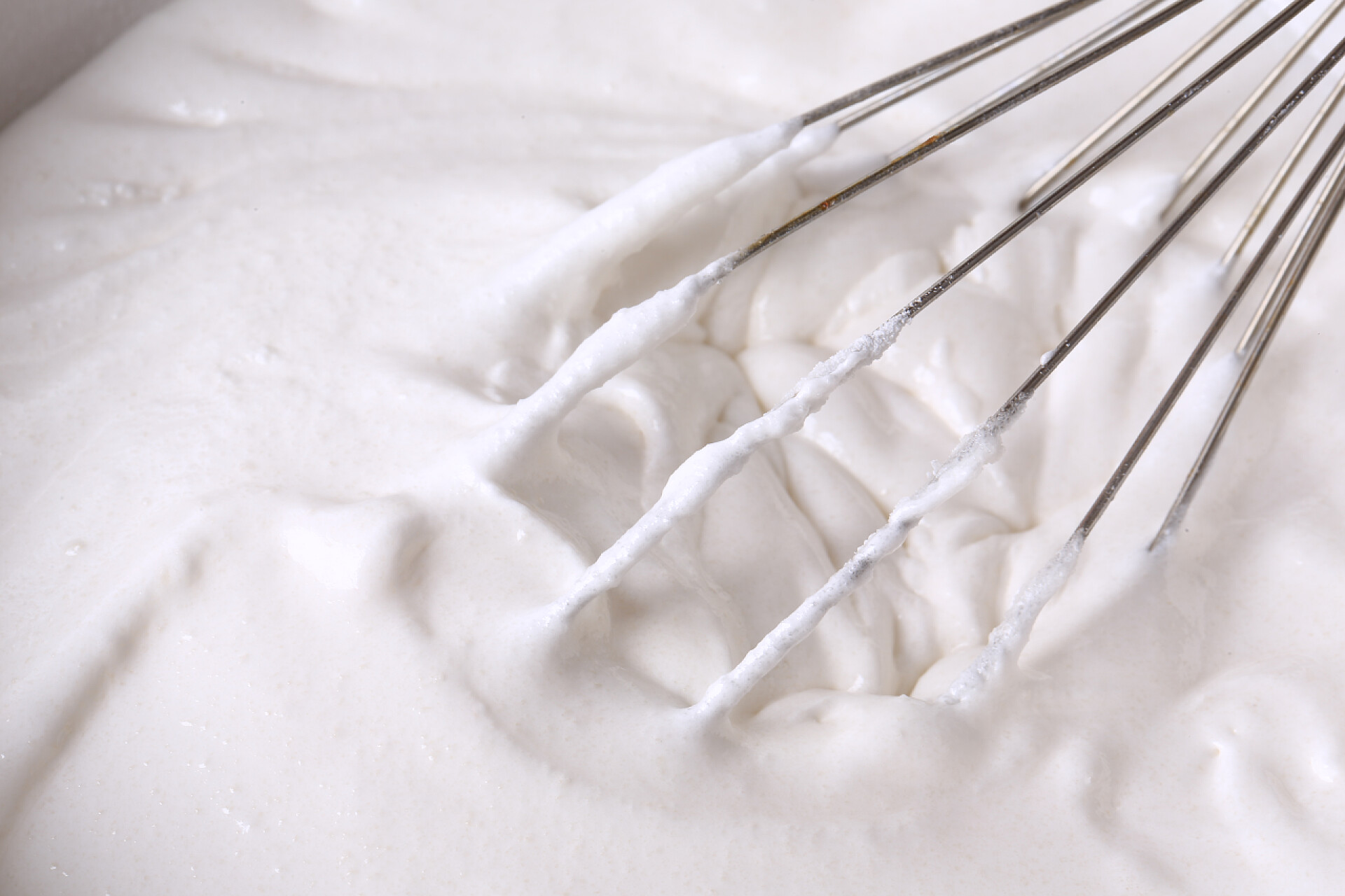 打蛋器正在搅拌奶油鞭打蛋清和糖烤奶油浇