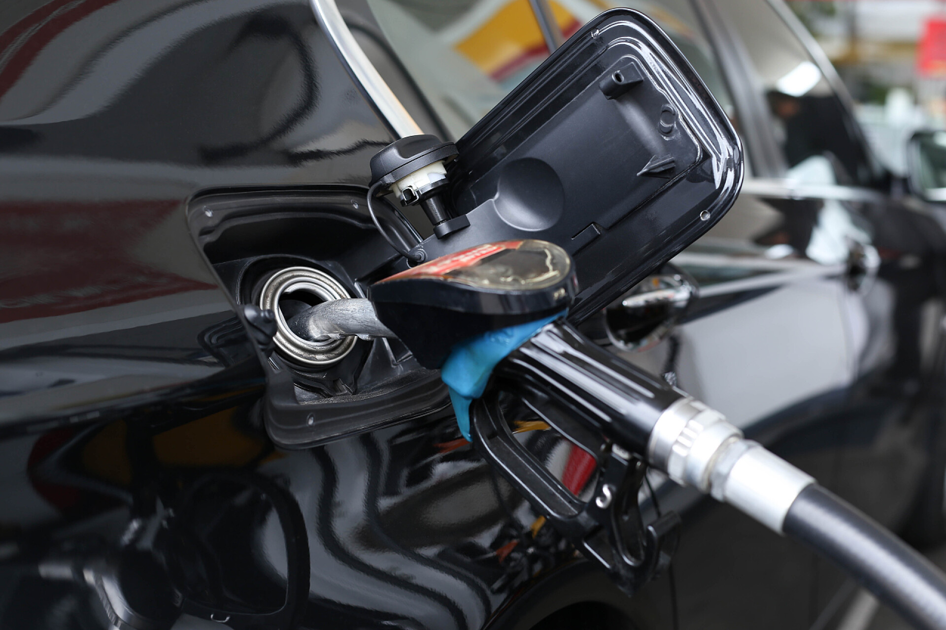 加油枪插在黑色的汽车油箱中在车里抽的汽油燃料