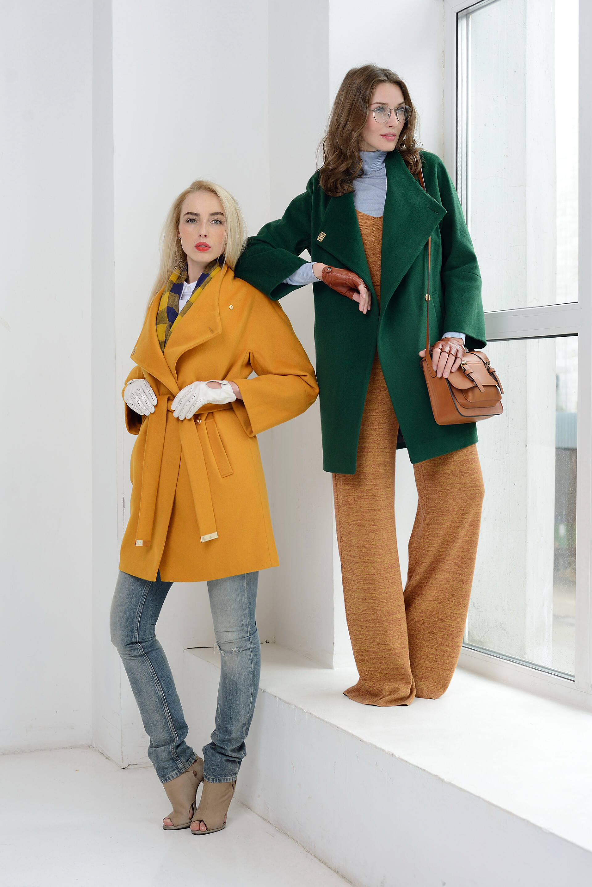 站在窗台上的美女模特在工作室里摆在大衣的女孩