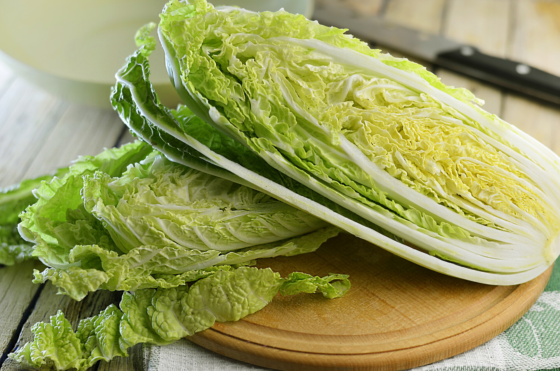 木桌上放着切开的黄心大白菜半白菜