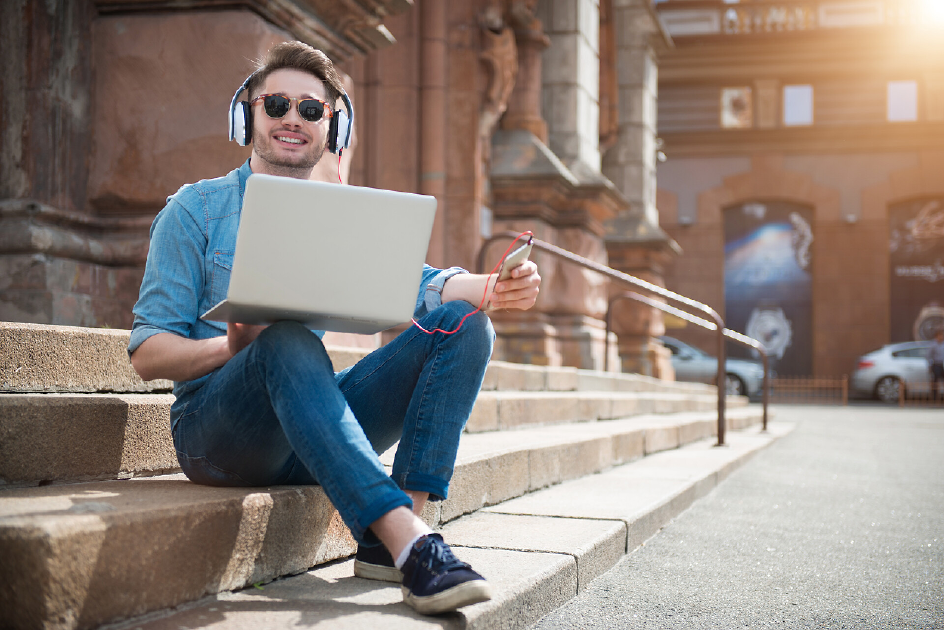 坐在楼梯上办公的男士积极的人坐在脚步声